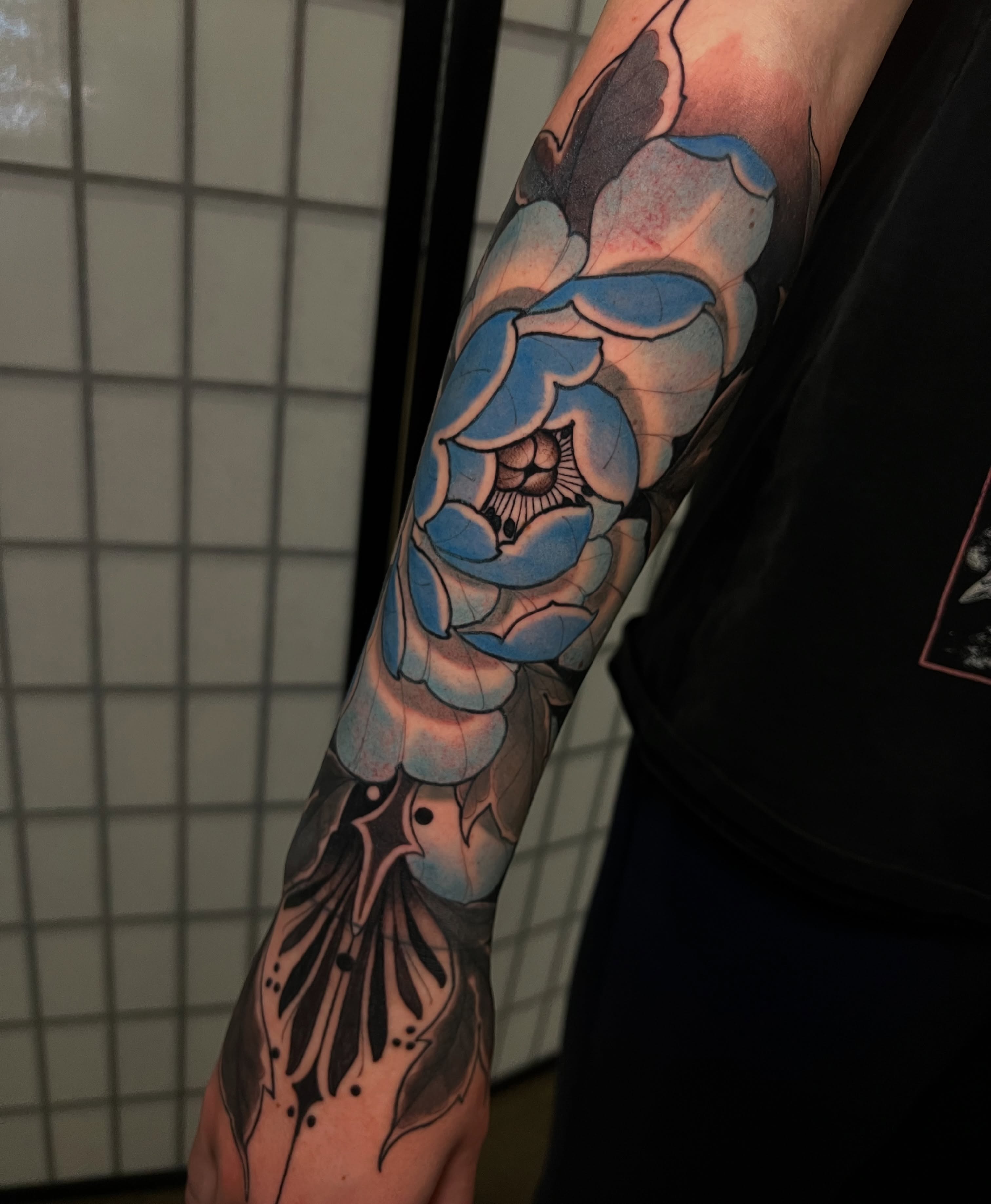 Blue rose new school tattoo on the forearm by Rennie Tattoo