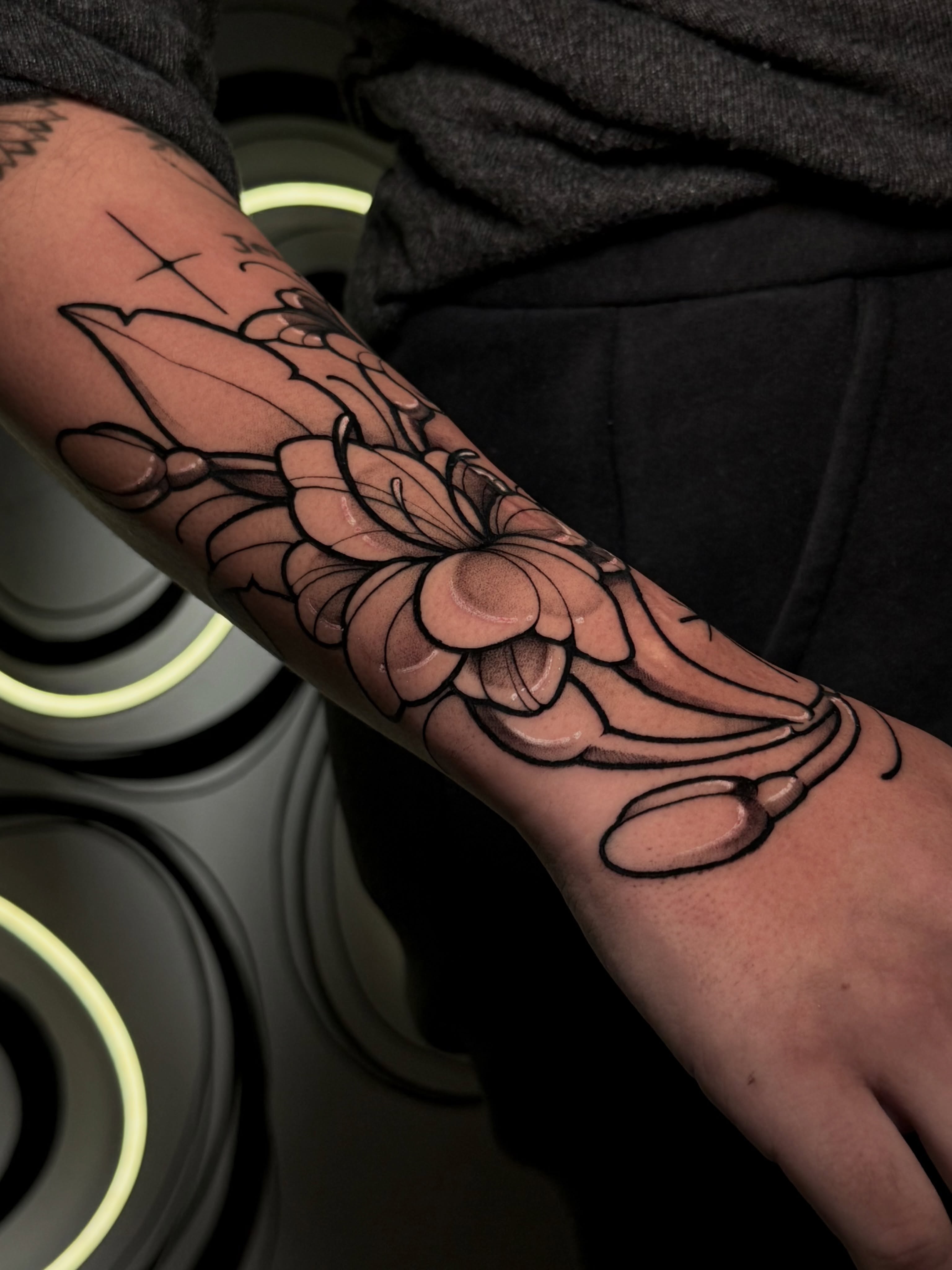 Lotus flower black and grey tattoo on the forearm by Gabrieli Folha