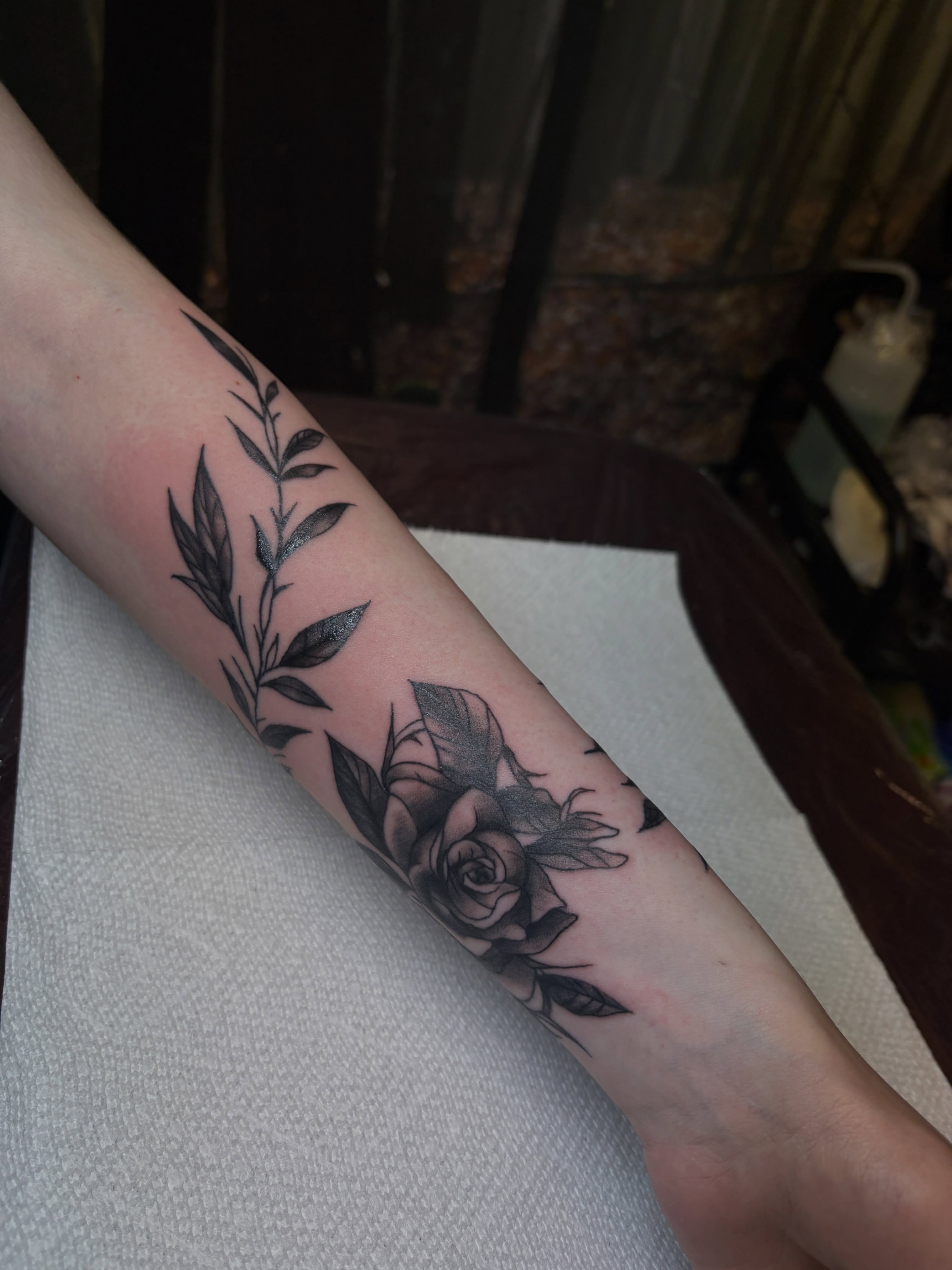 Rose and leaves black and grey tattoo on the forearm by ⋆.˚ ☾ .⭒˚ alaina