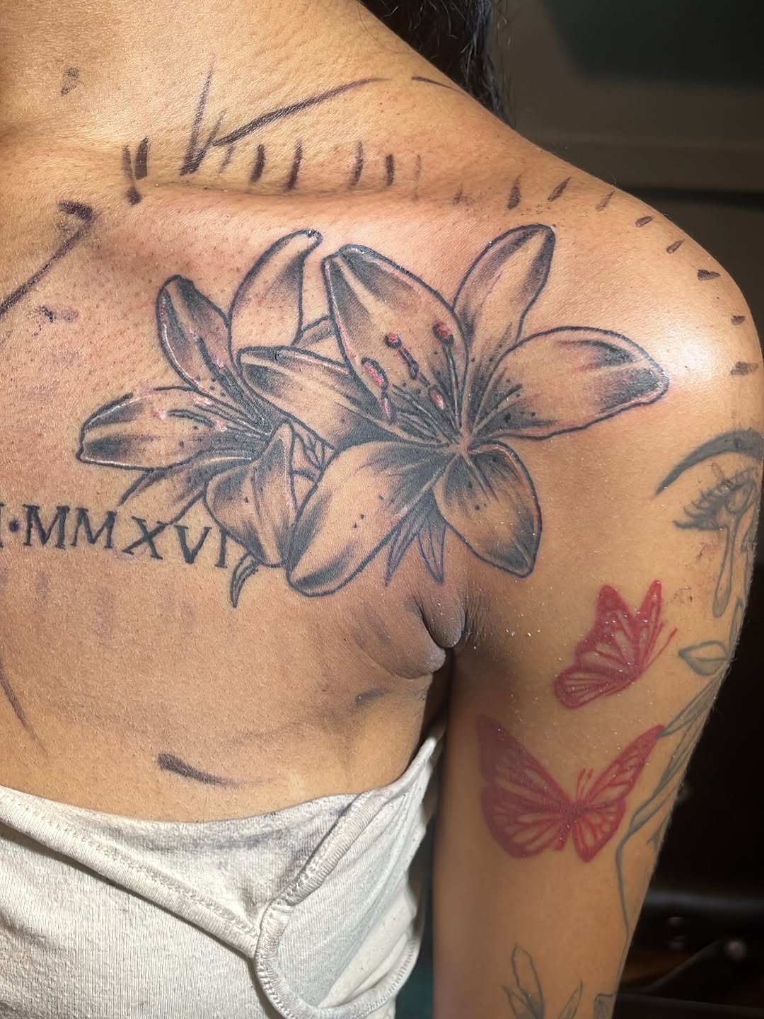 Lilies and roman numerals fine line tattoo on the shoulder by SpicyMvstardInkk