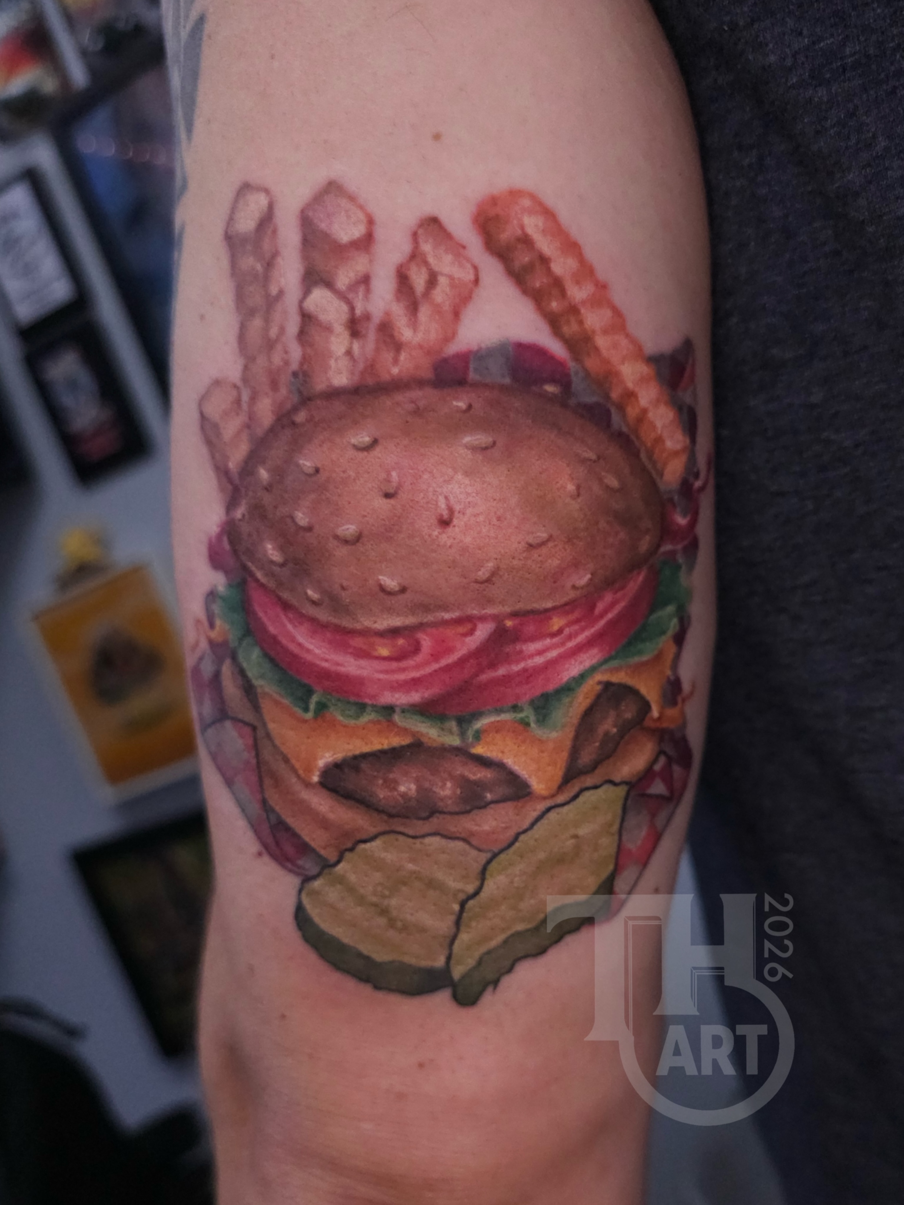 Hamburger and fries realism tattoo on the forearm by Thomas Harris