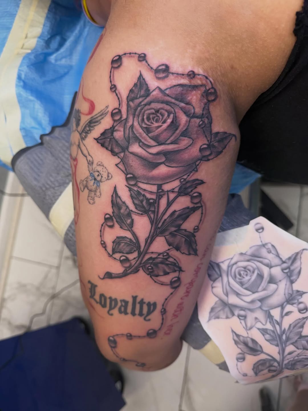 Rose with water droplets and lettering dotwork tattoo on the forearm by linda perez