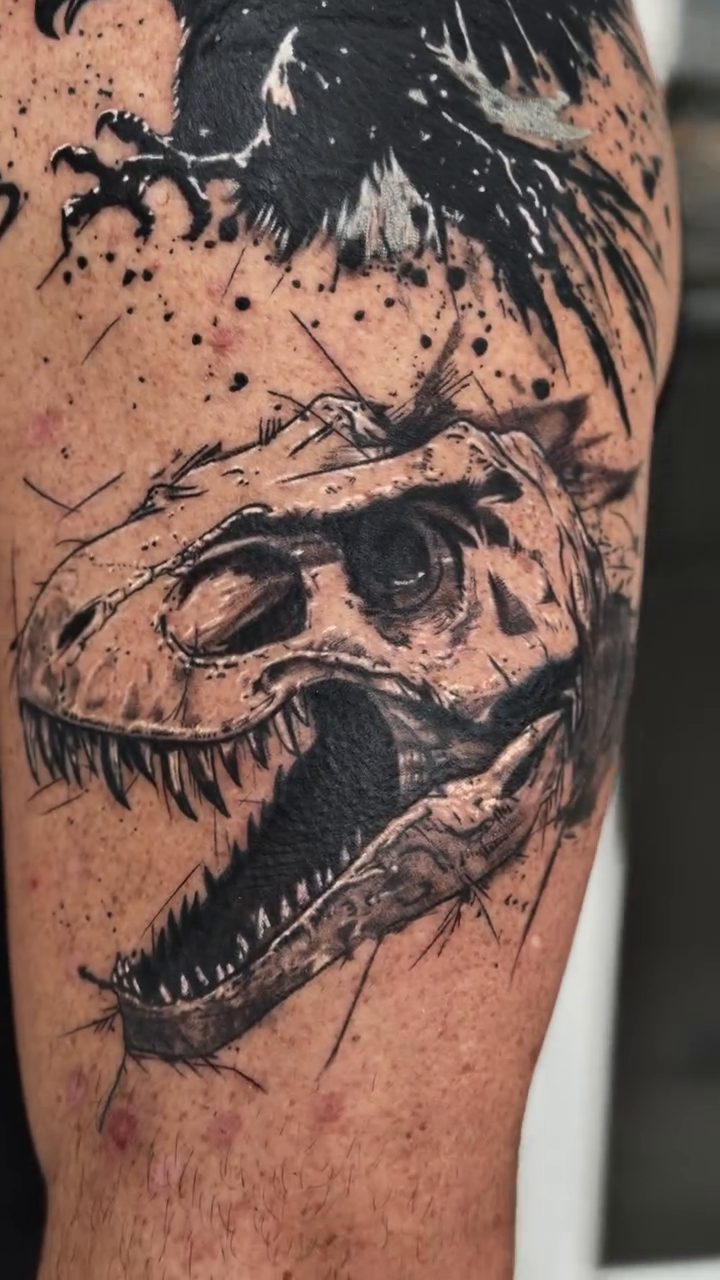 Eagle and dinosaur skull realism tattoo on the upper arm by Raciel Fabian Romero