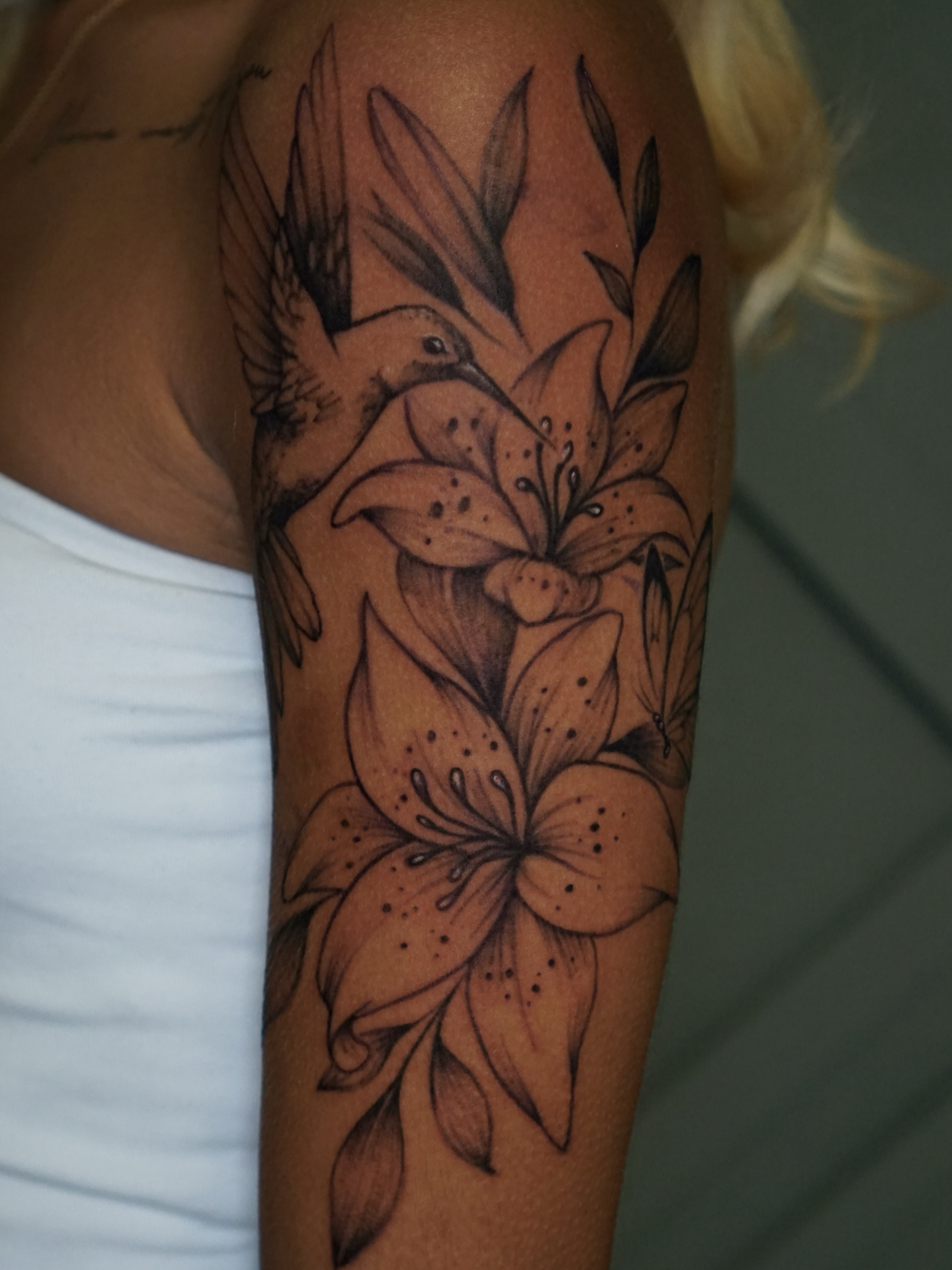 Lilies and hummingbird realism tattoo on the forearm by Nicholas Capellan, Winter Park, Florida