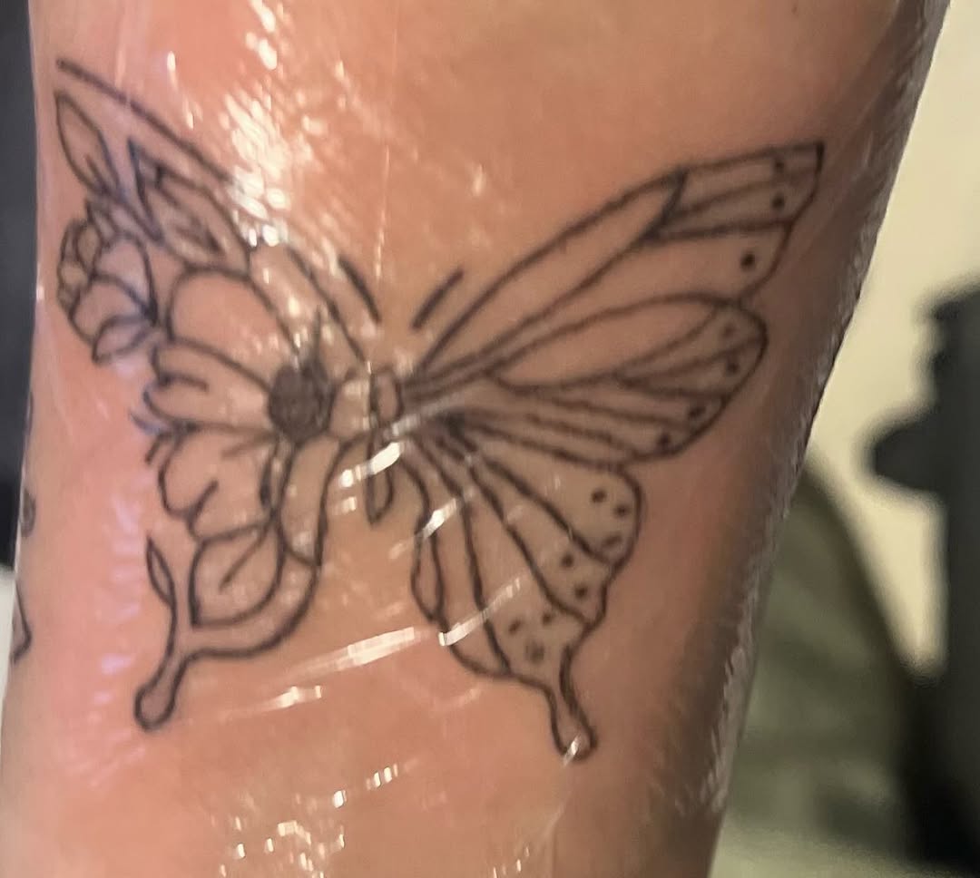 Butterfly and flower fine line tattoo on the forearm by The feminine ink