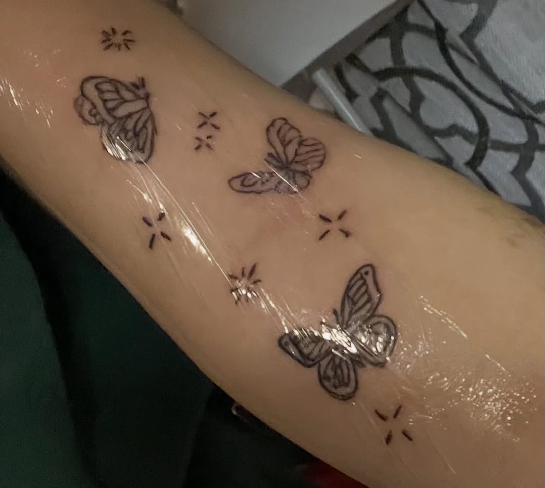 Butterflies and stars fine line tattoo on the forearm by The feminine ink