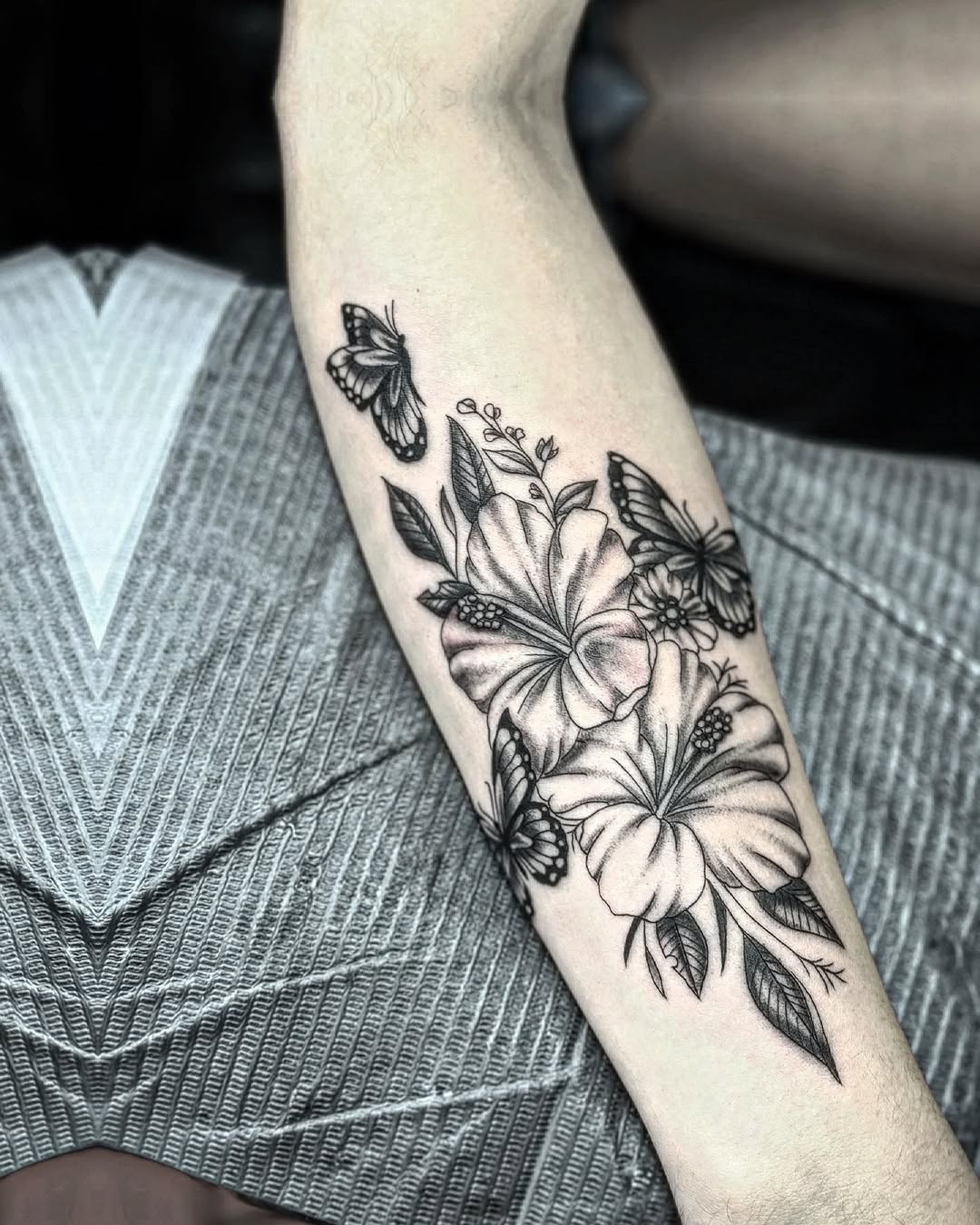 Hibiscus flowers and butterflies dotwork tattoo on the forearm by Murl Dietrich