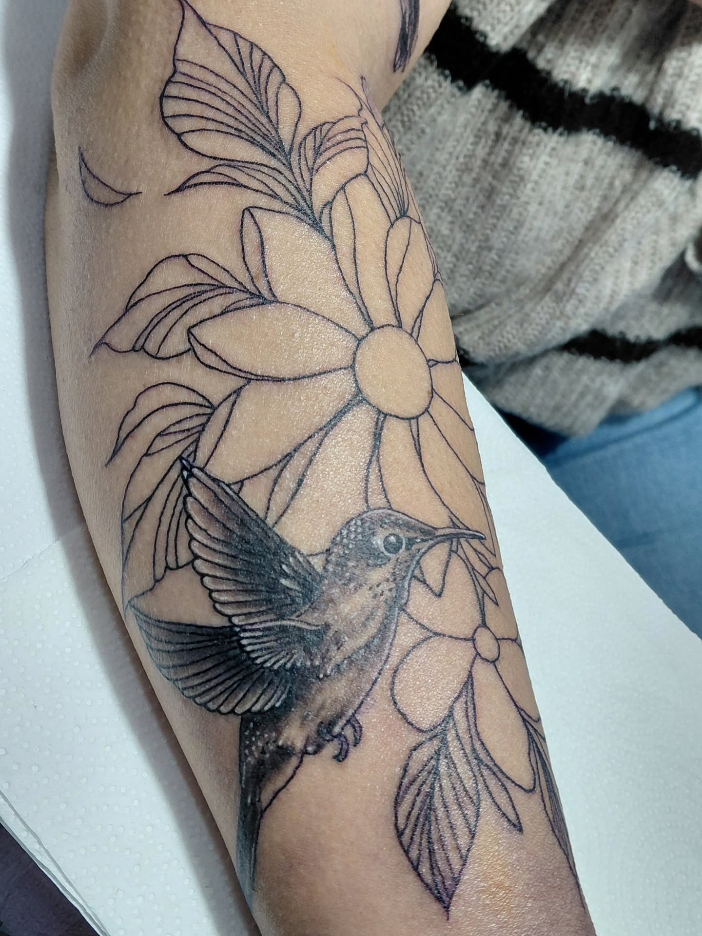 Hummingbird and flower black and grey tattoo on the forearm by Jose Rodriguez