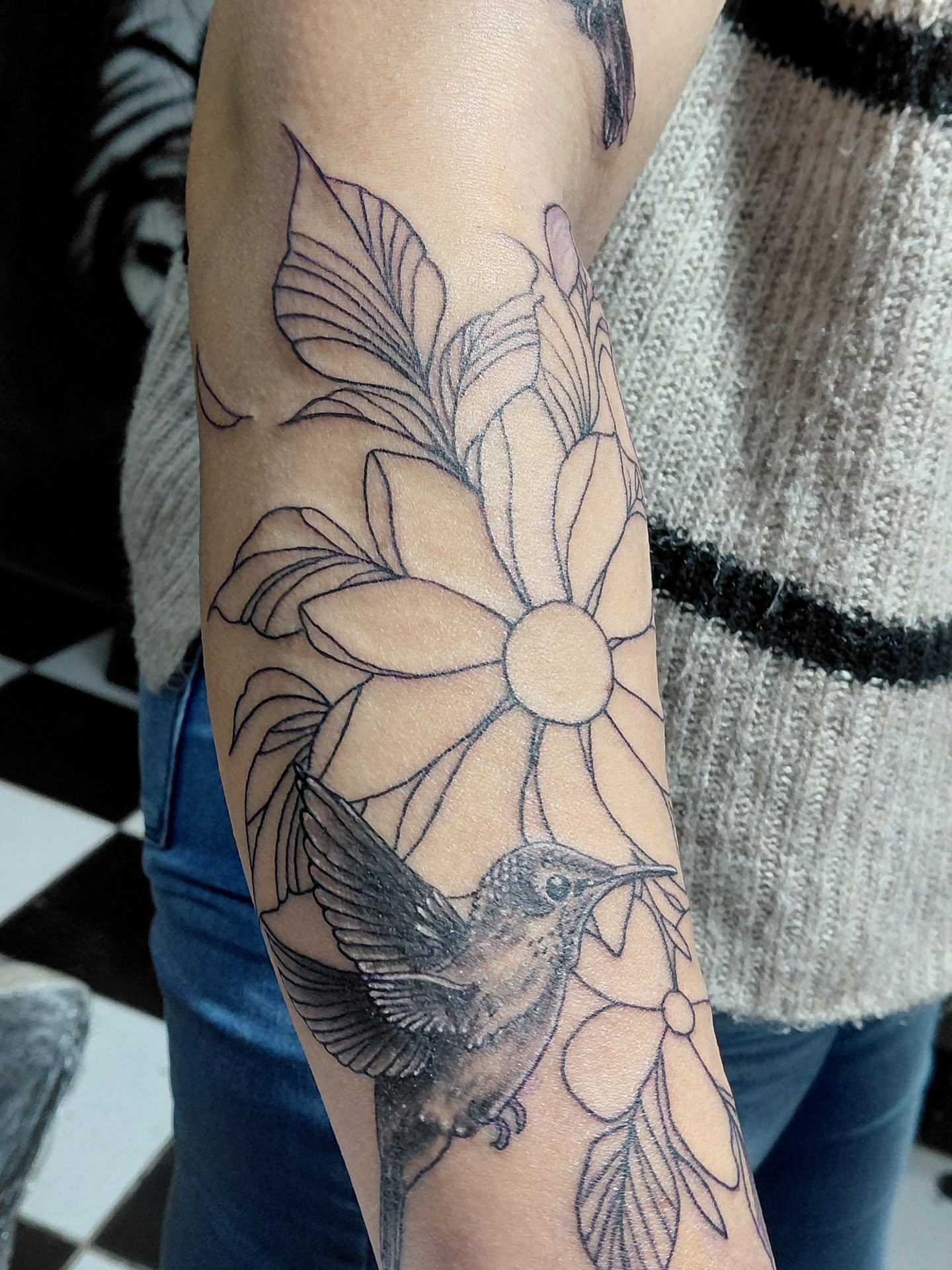Hummingbird and flower black and grey tattoo on the forearm by Jose Rodriguez