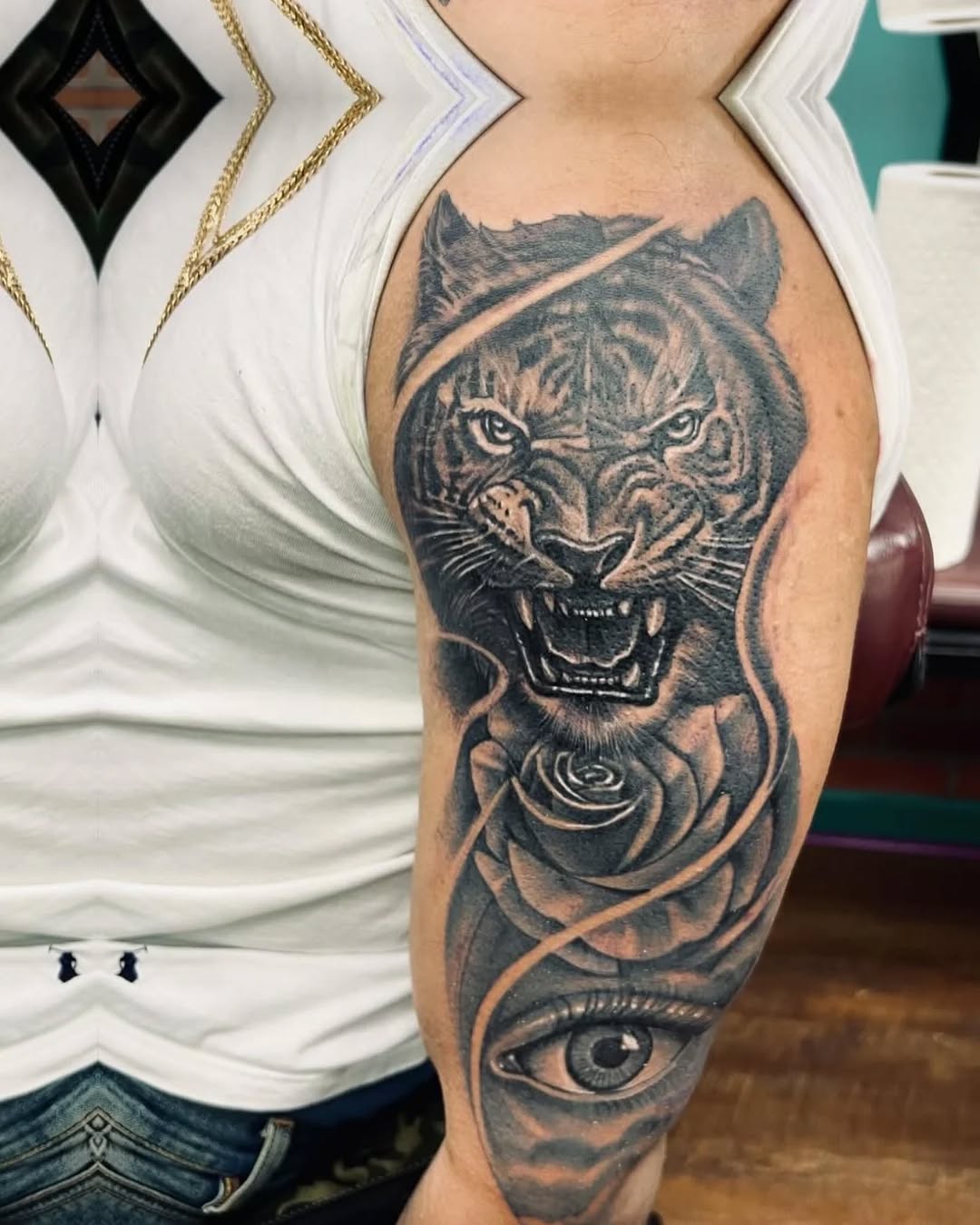 Tiger, rose, and eye realism tattoo on the forearm by Watson Gutkowski