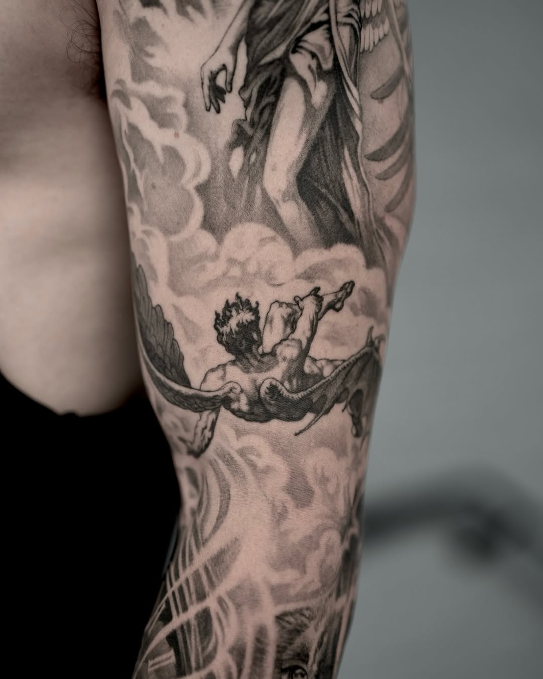Angelic figures in clouds realism tattoo on the forearm by Mark Vata
