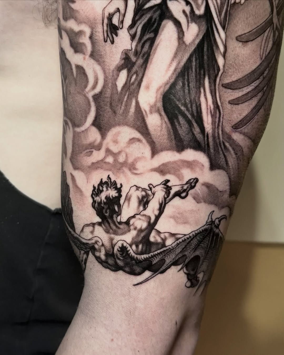 Fallen angel in clouds realism tattoo on the forearm by Mark Vata