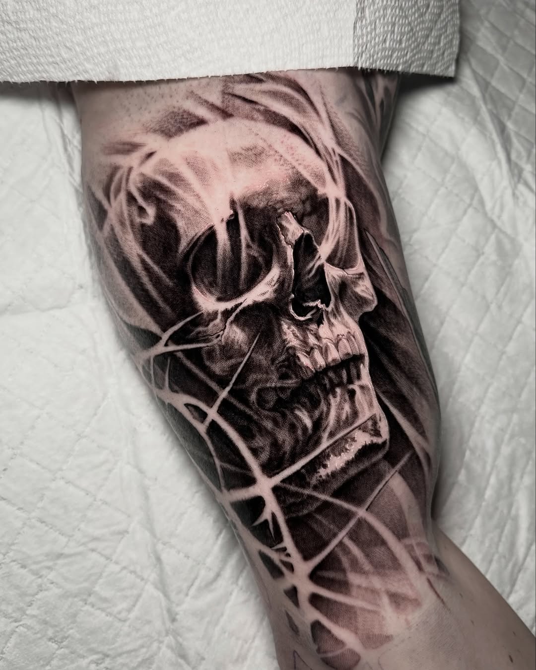 Skull with abstract smoke and lines realism tattoo on the forearm by Mark Vata