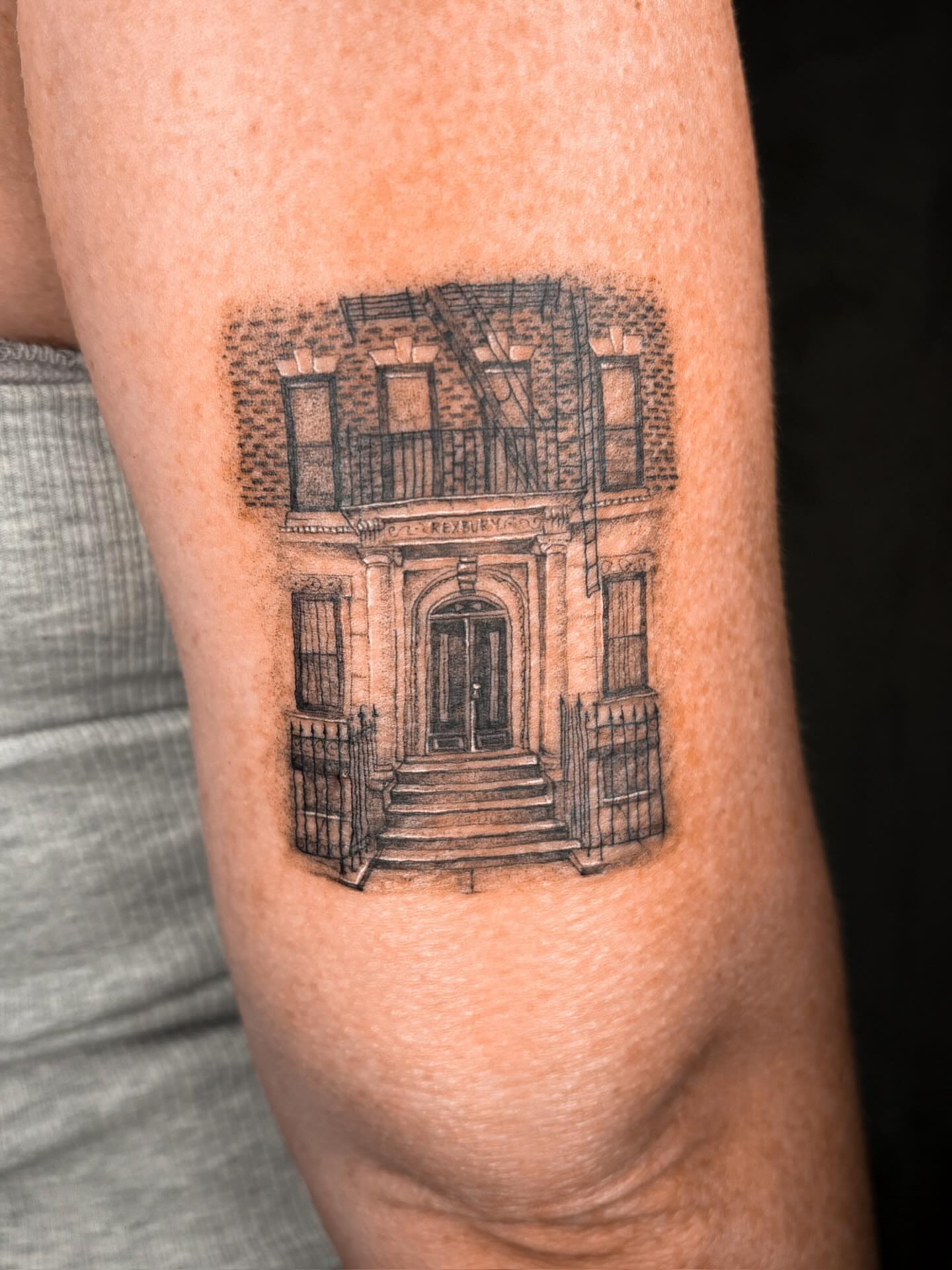 Building facade black and grey tattoo on the forearm by Annie