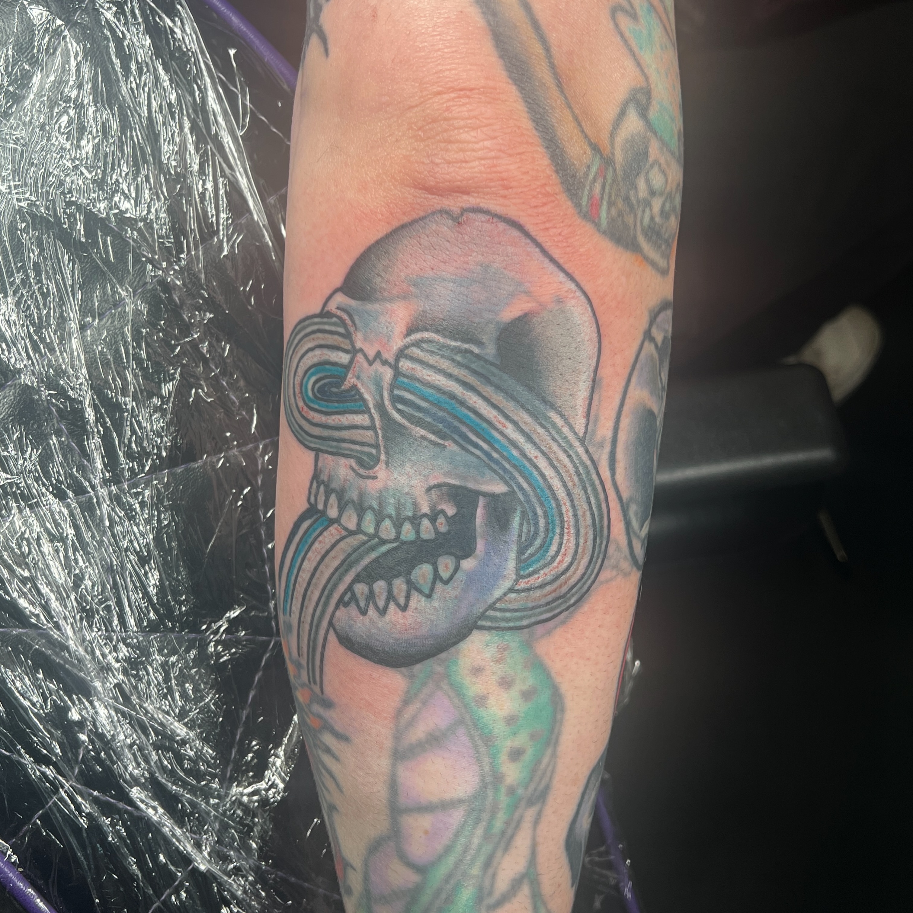 Skull with swirling patterns new school tattoo on the forearm by Brian Mock