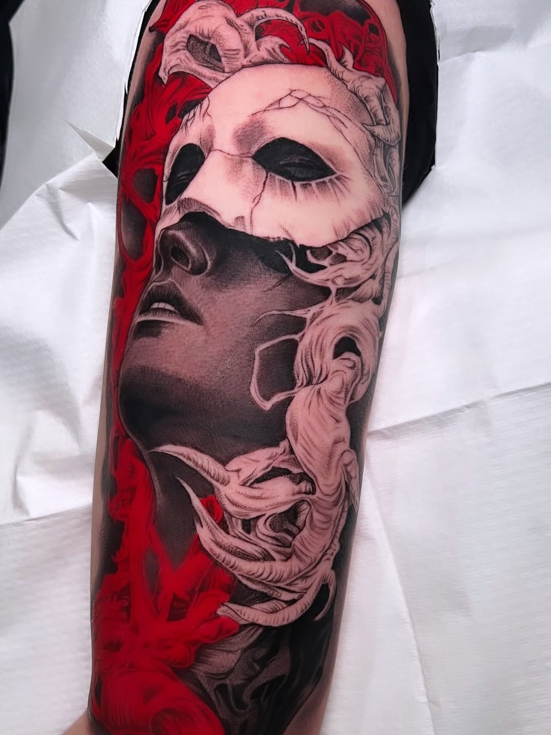 Mask and face surrealism tattoo on the forearm by BJ