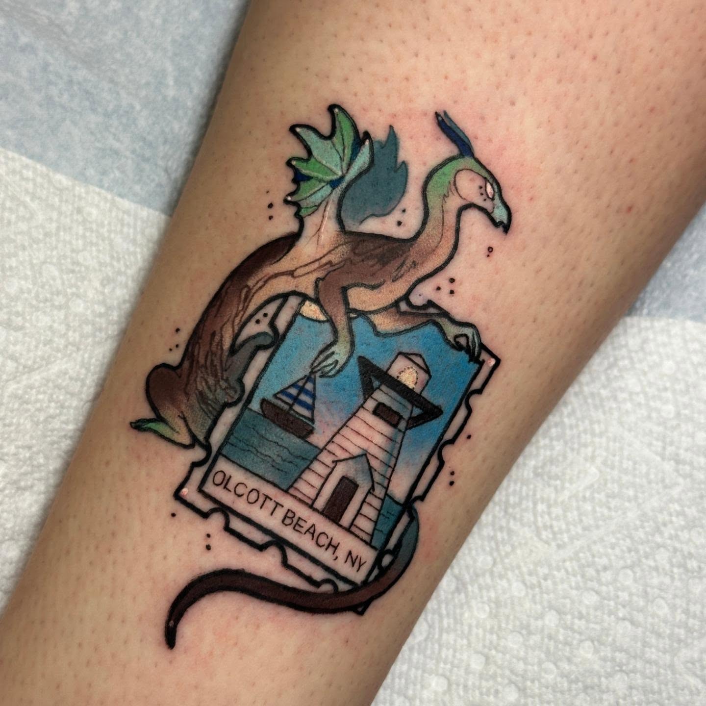 Dragon and lighthouse American traditional tattoo on the forearm by Sasha Wren
