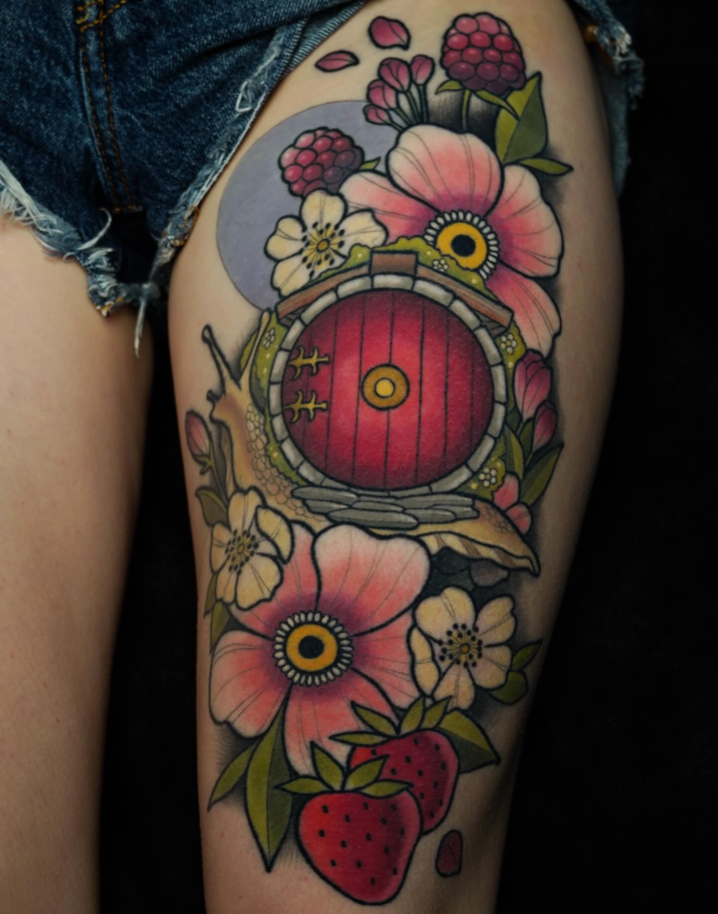 Hobbit door with floral elements new school tattoo on the thigh by Brooke Borden