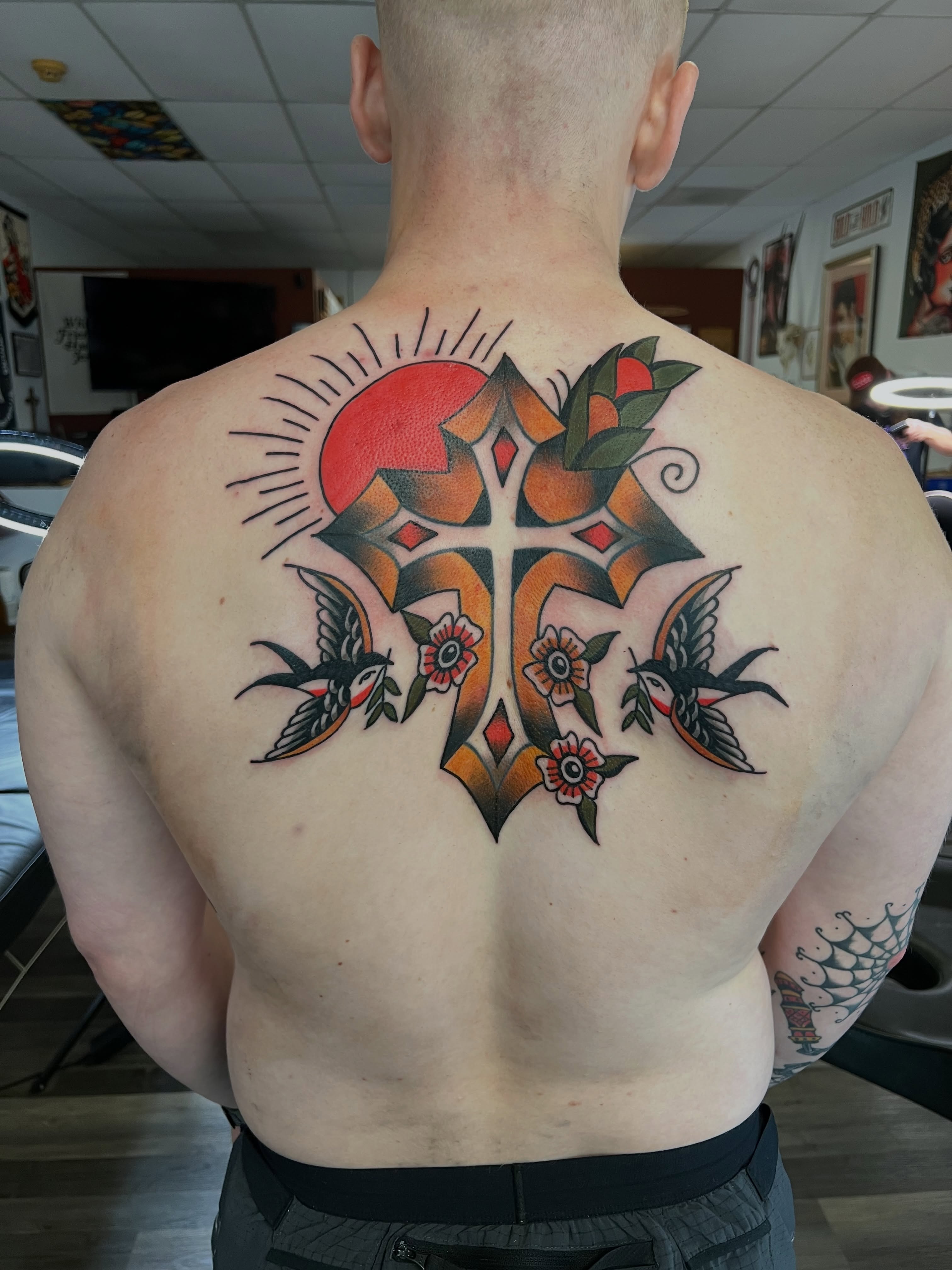 Cross with floral and bird motifs American traditional tattoo on the back by Christopher Durao