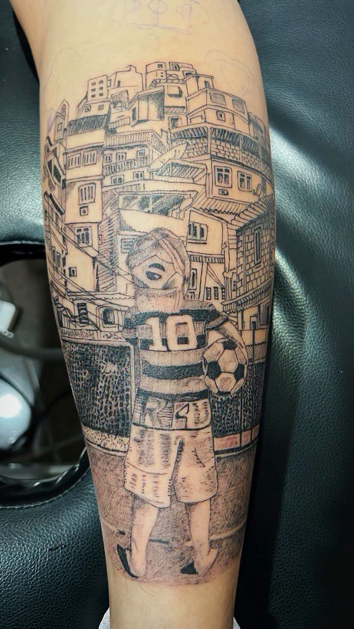 Favela scene with a soccer player tattoo on the forearm by Ink Napawong