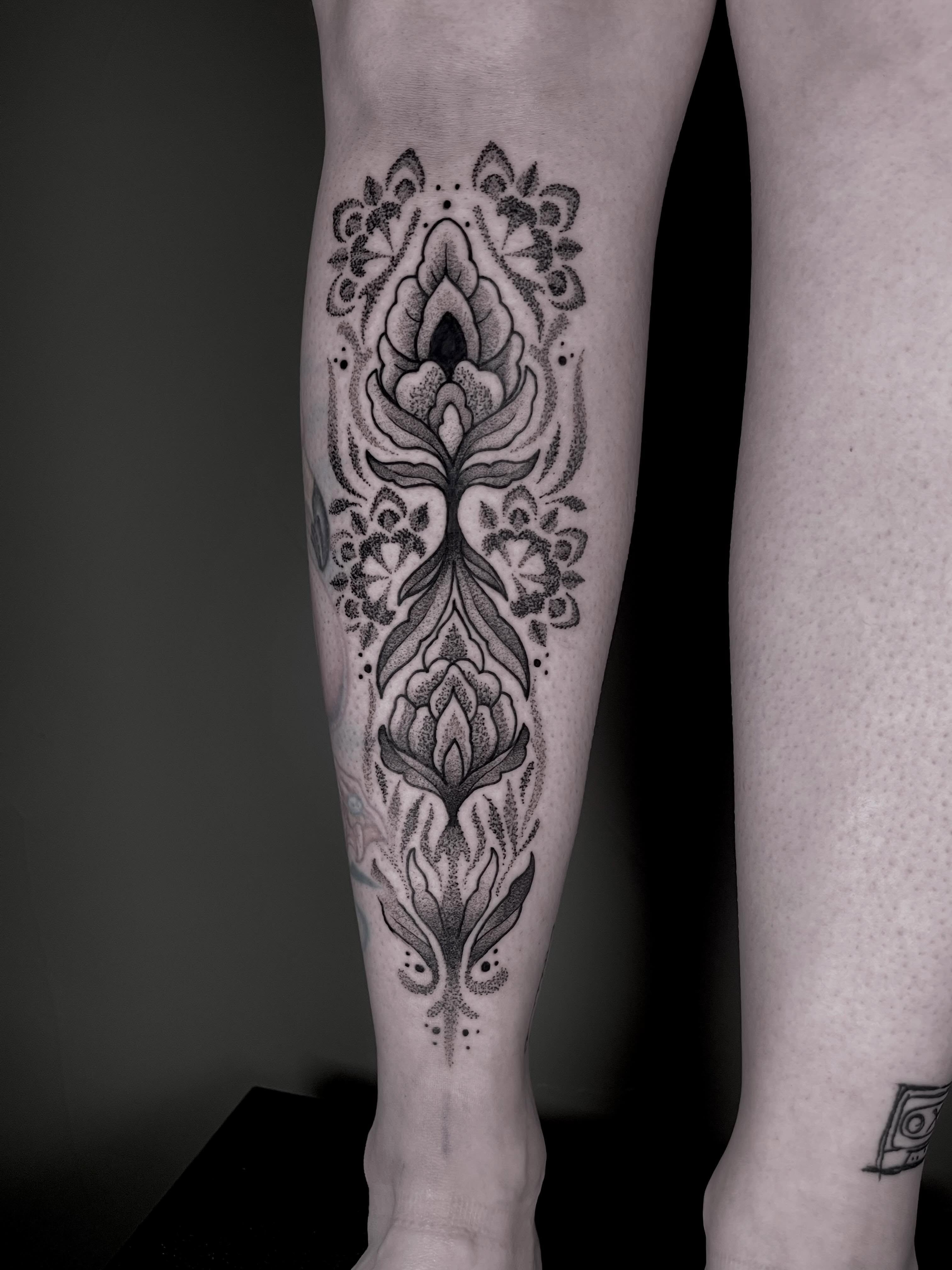 Lotus flowers dotwork tattoo on the calf by Destiny Tolman