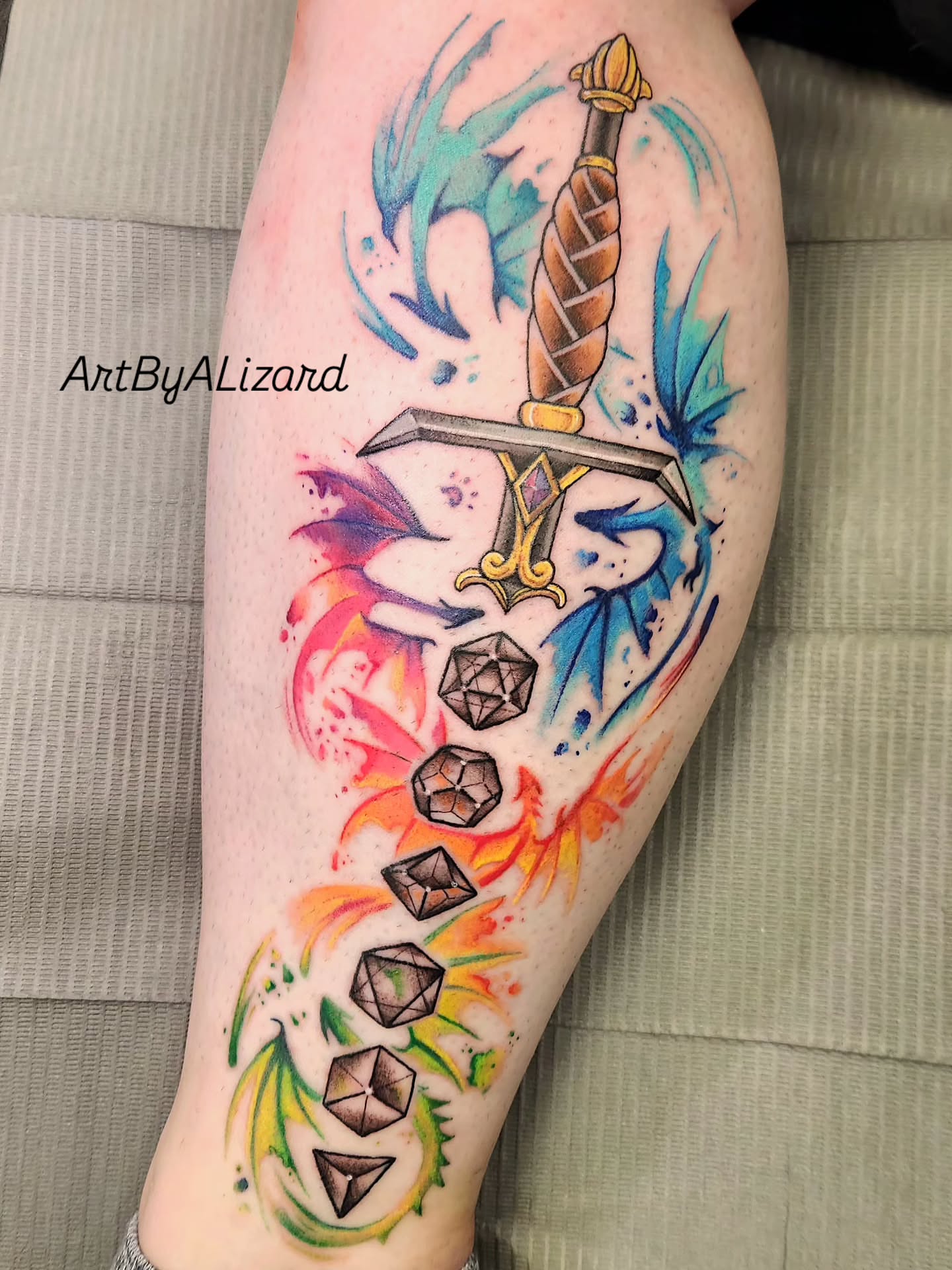 Sword and gemstones watercolor tattoo on the forearm by Elizabeth Stepp