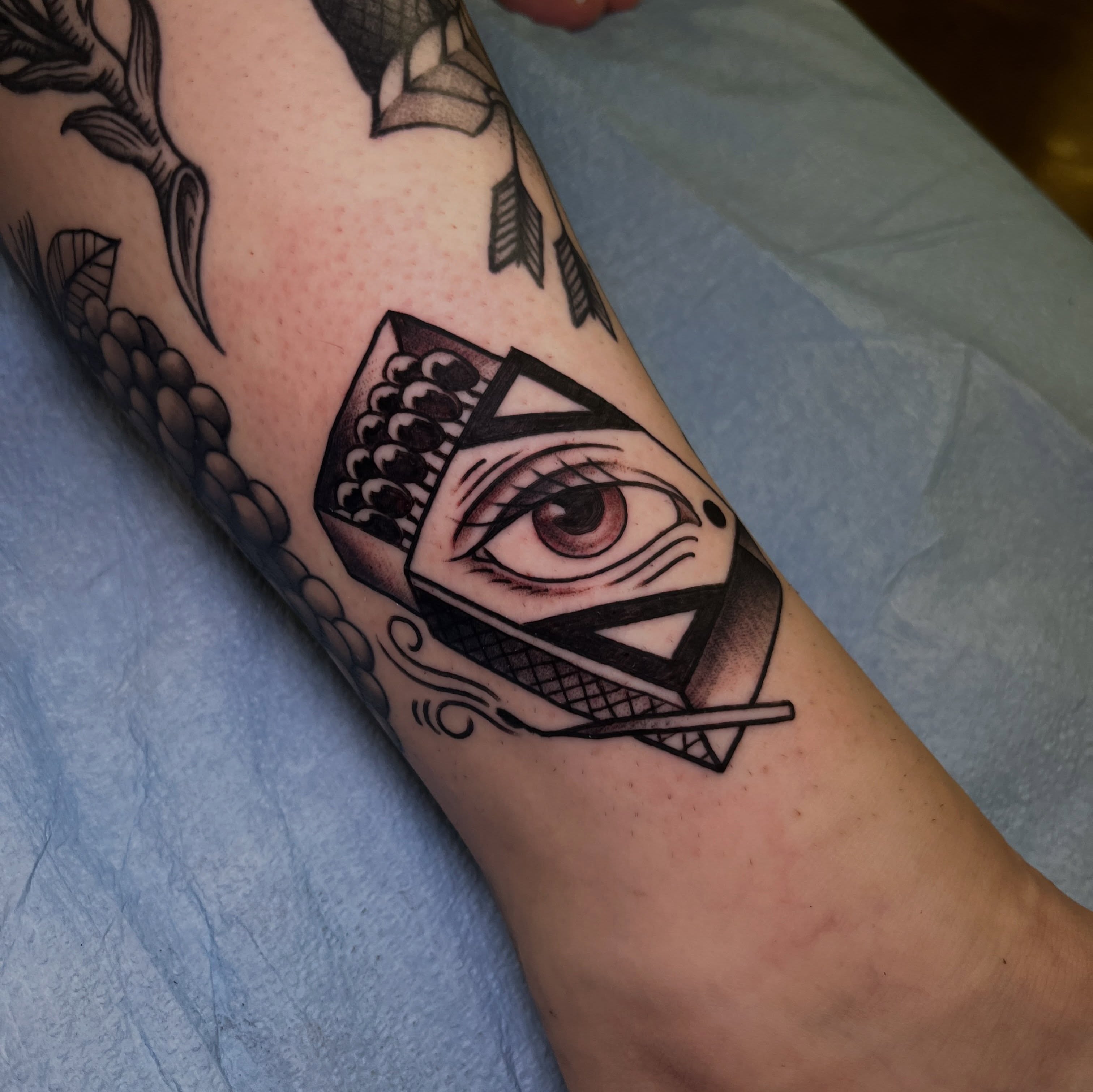 Eye within a box geometric tattoo on the forearm by Evan Perrine