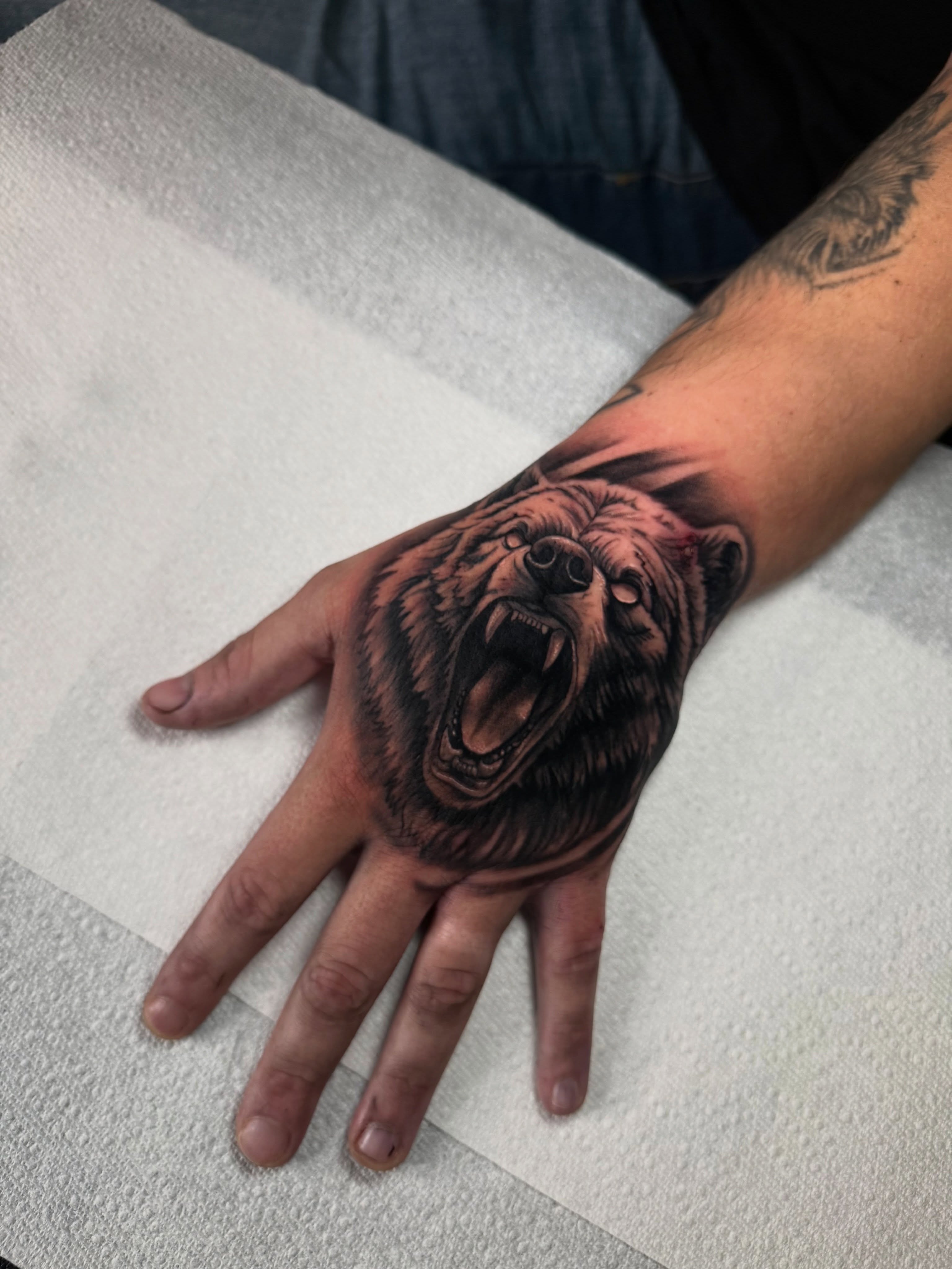 Bear realism tattoo on the hand by Christian Hood
