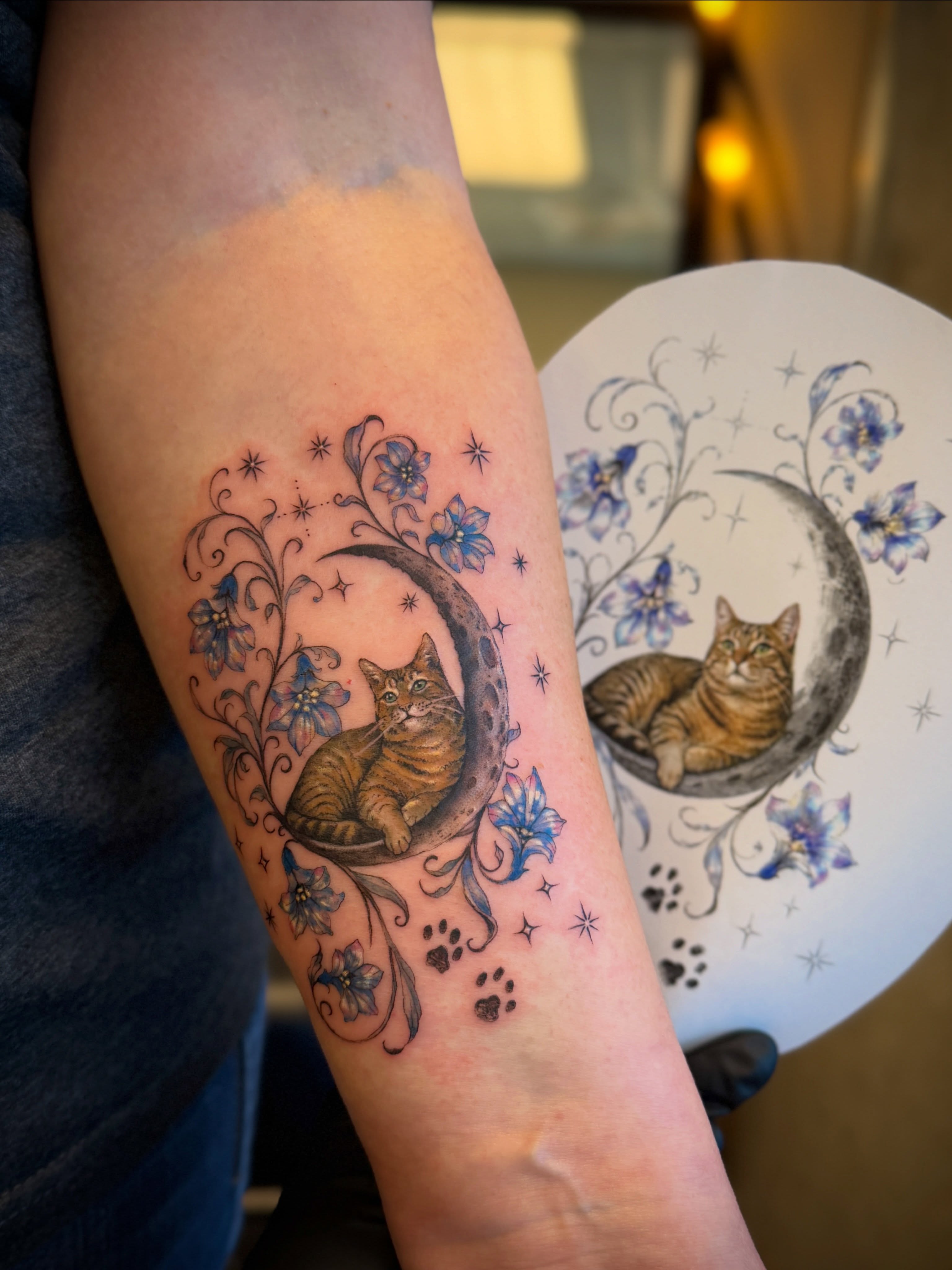 Cat in moon realism tattoo on the forearm by Aristova Anastasia