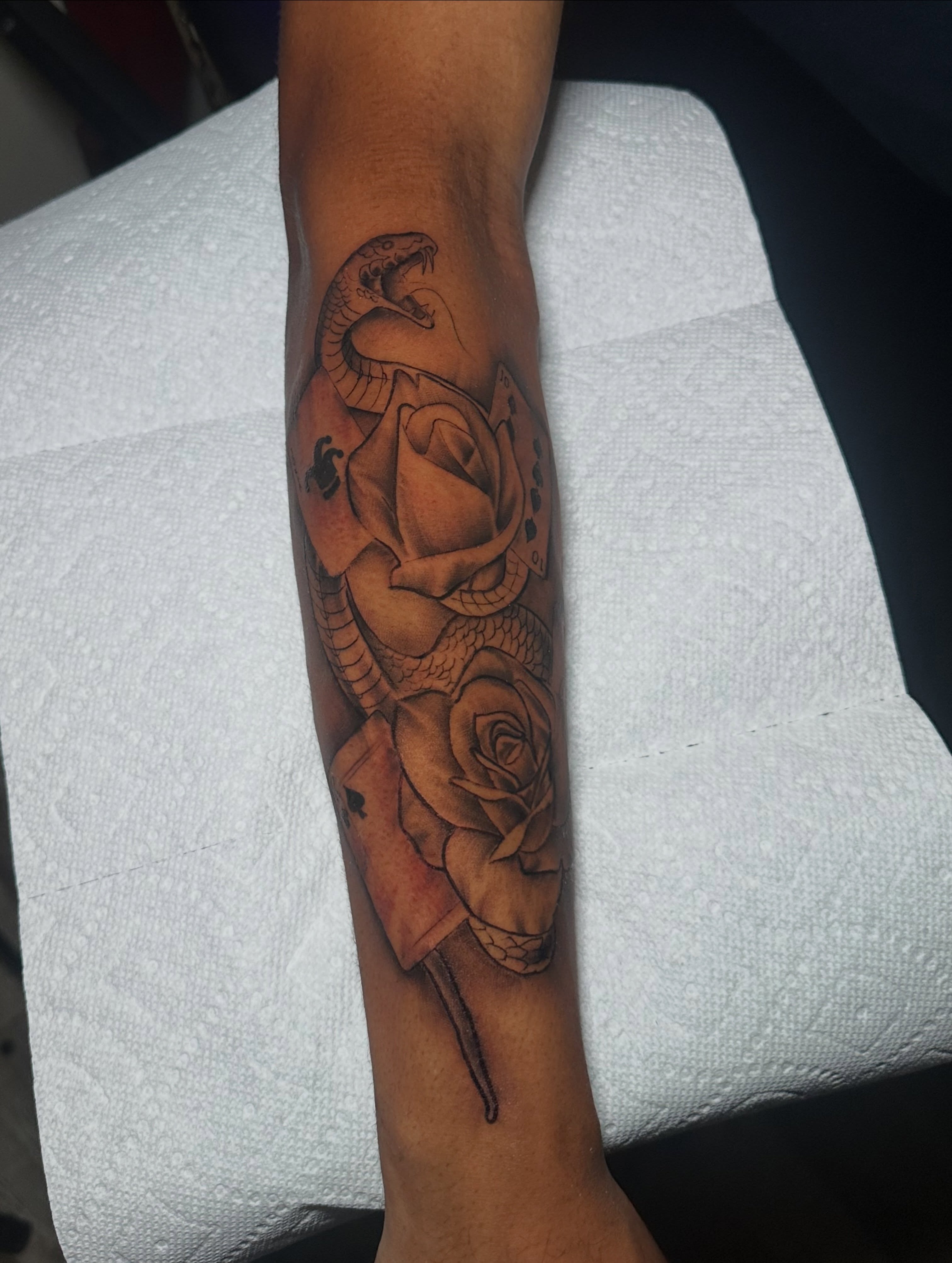 Snake and rose realism tattoo on the forearm by @tattedbytuck