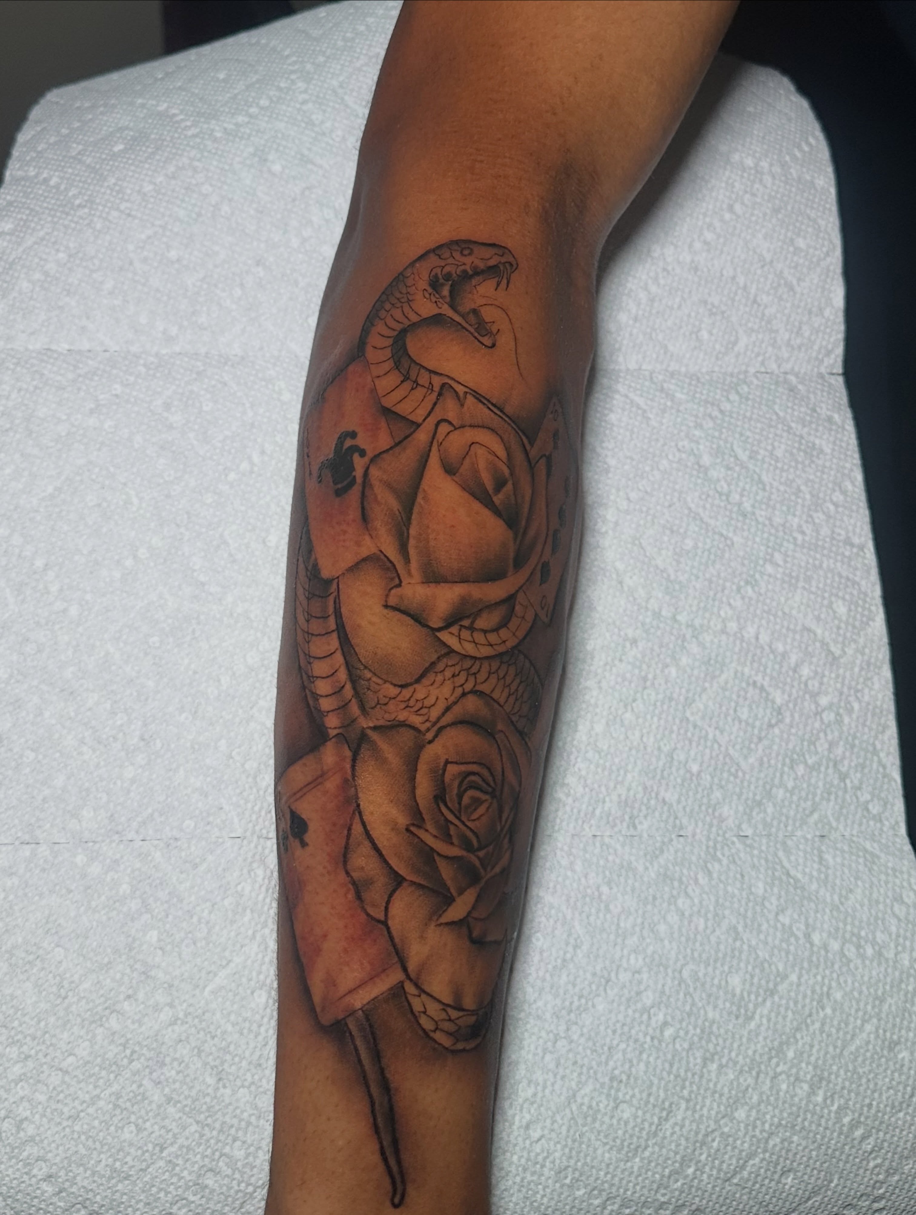 Snake and roses black and grey tattoo on the forearm by @tattedbytuck