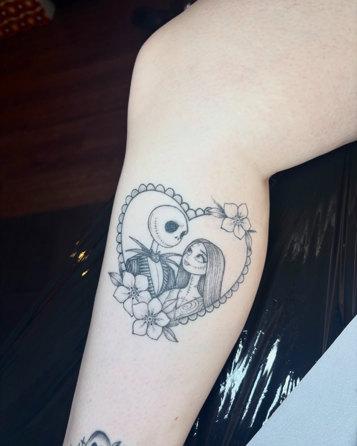 Jack and Sally dark realism tattoo on the forearm by Charlotte Brown, Leeds, England