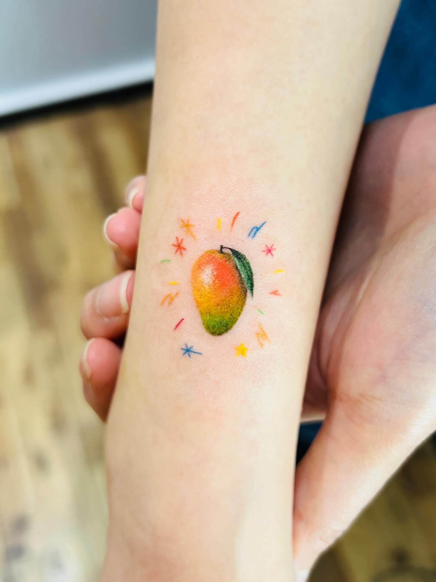 Mango watercolor tattoo on the forearm by Purinn