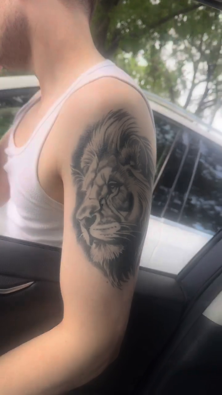 Lion portrait tattoo realism tattoo on the upper arm by Willi Tattoos👹