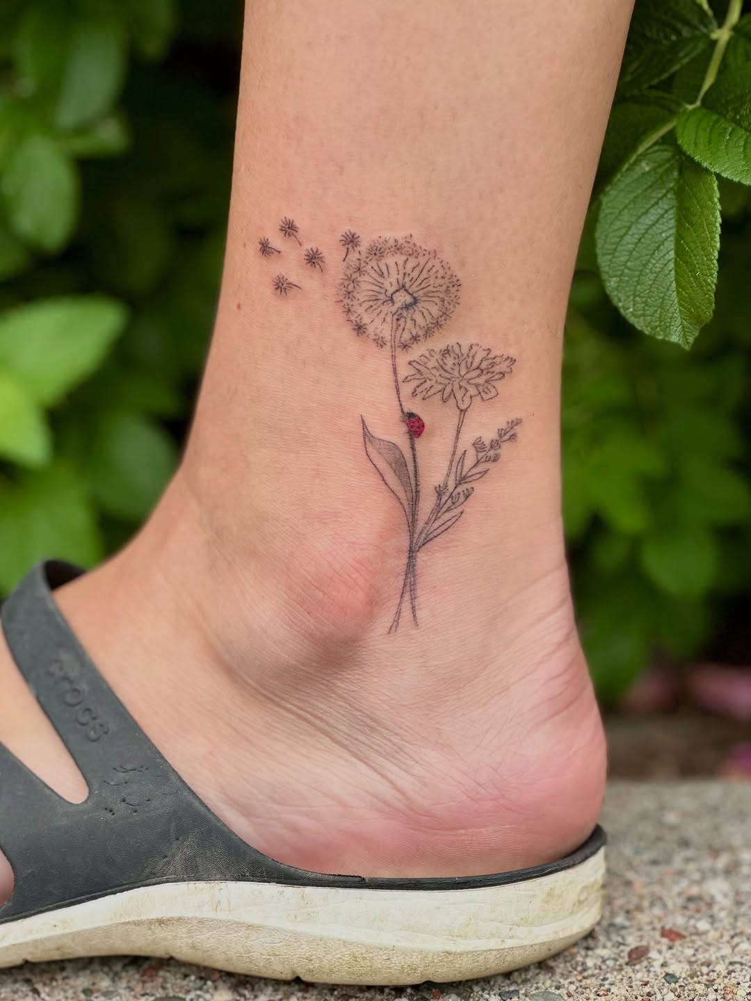 Dandelion and ladybug minimalist tattoo on the foot by Liz