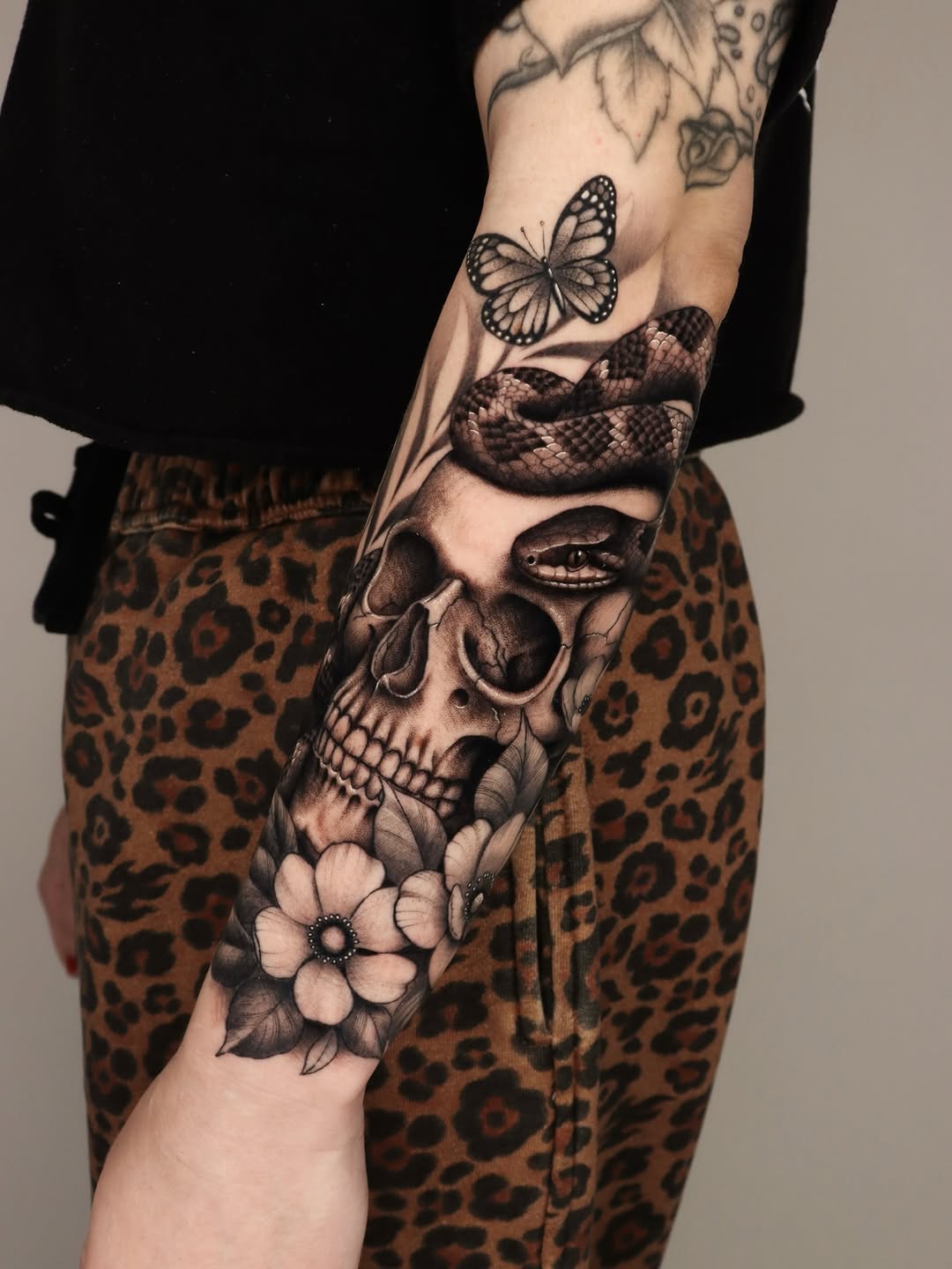 Skull with snake and butterfly realism tattoo on the forearm by Jeff Reindel