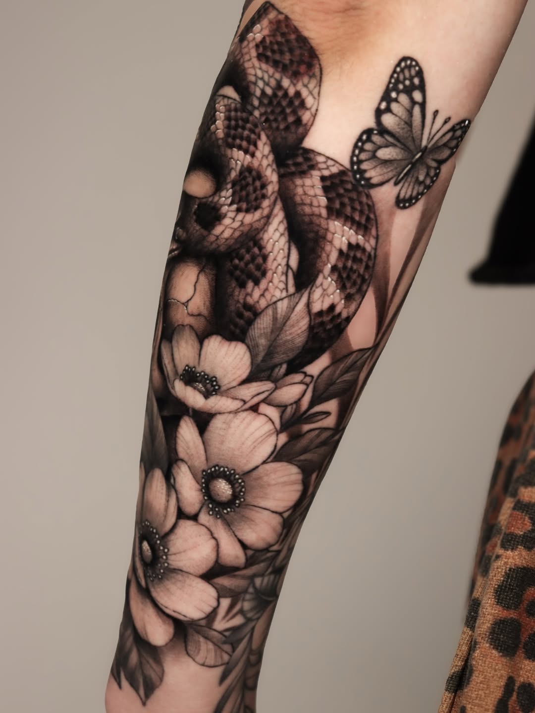 Snake and flowers dotwork tattoo on the forearm by Jeff Reindel