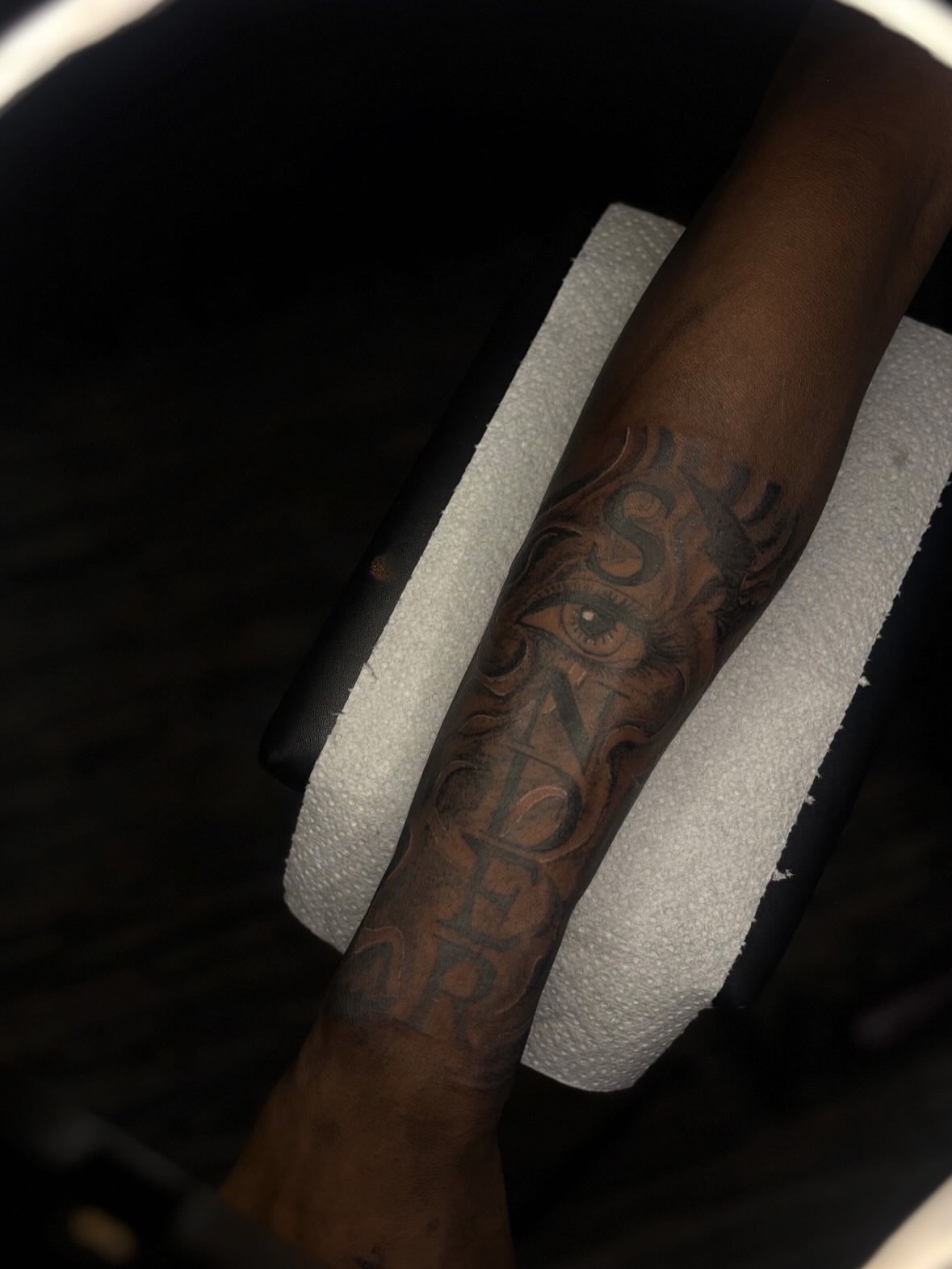 Eye and lettering Chicano tattoo on the forearm by 🏳️‍🌈