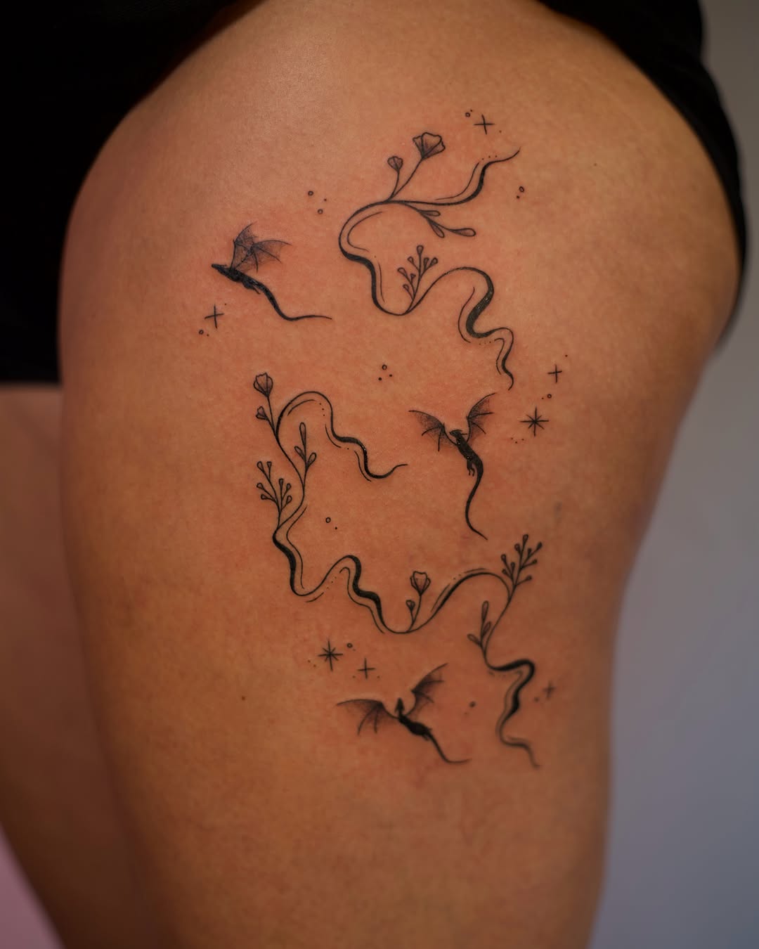 Abstract floral design fine line tattoo on the thigh by Jess