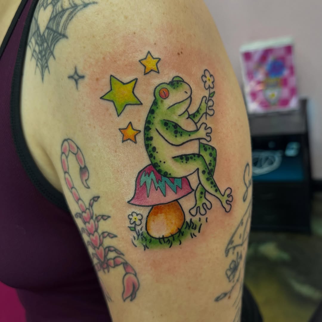 Frog new school tattoo on the upper arm by Jada Reynolds
