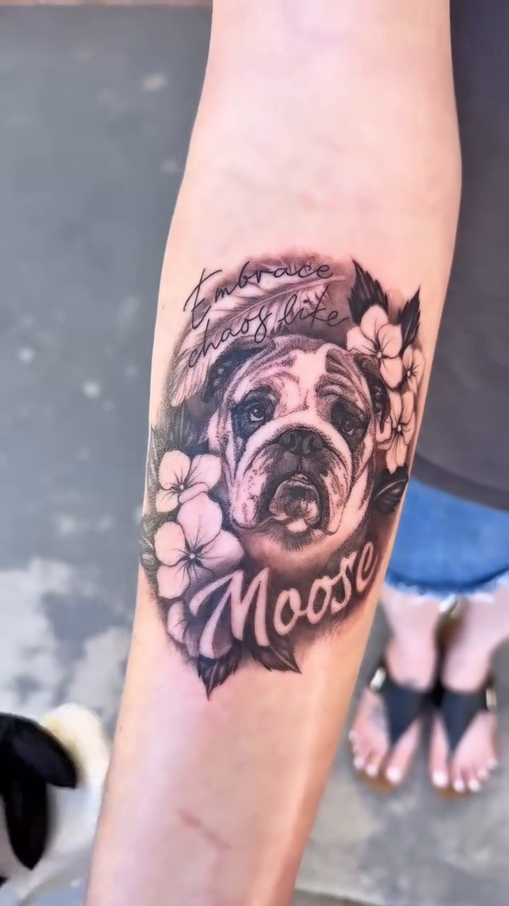 Bulldog portrait with flowers and name realism tattoo on the forearm by Maggie George