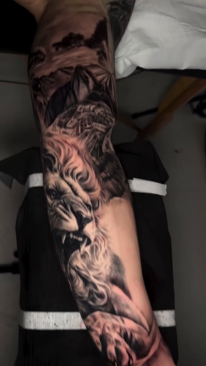 Lion and landscape realism tattoo by Montreal Tattoo Artist