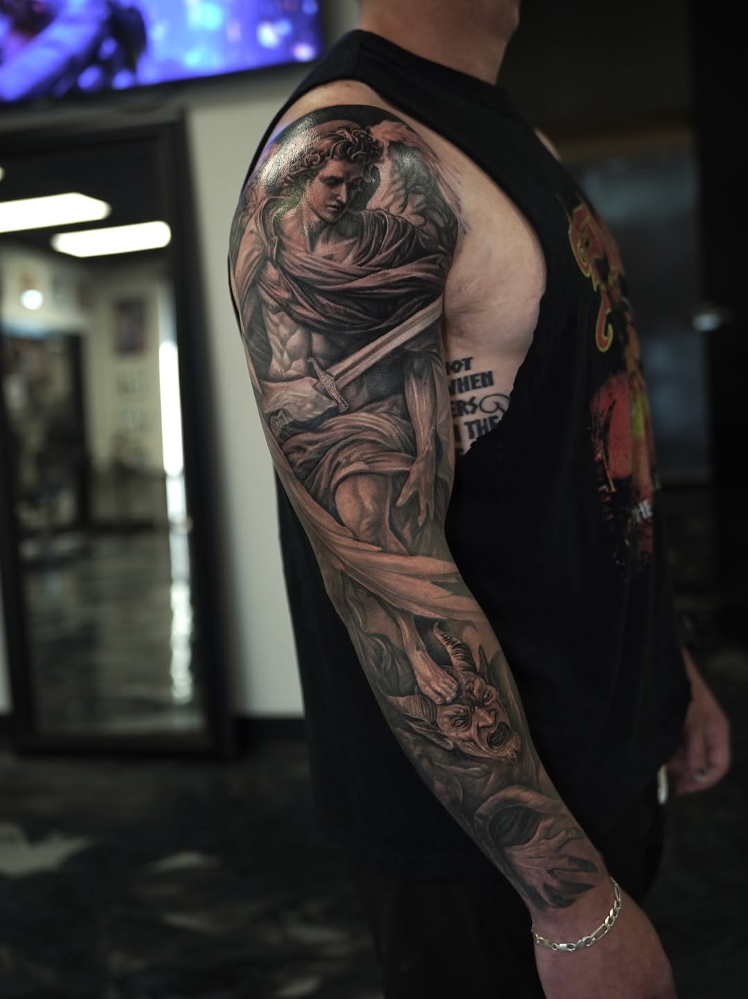 Angel and demon realism tattoo on the upper arm by Nelson Tellez