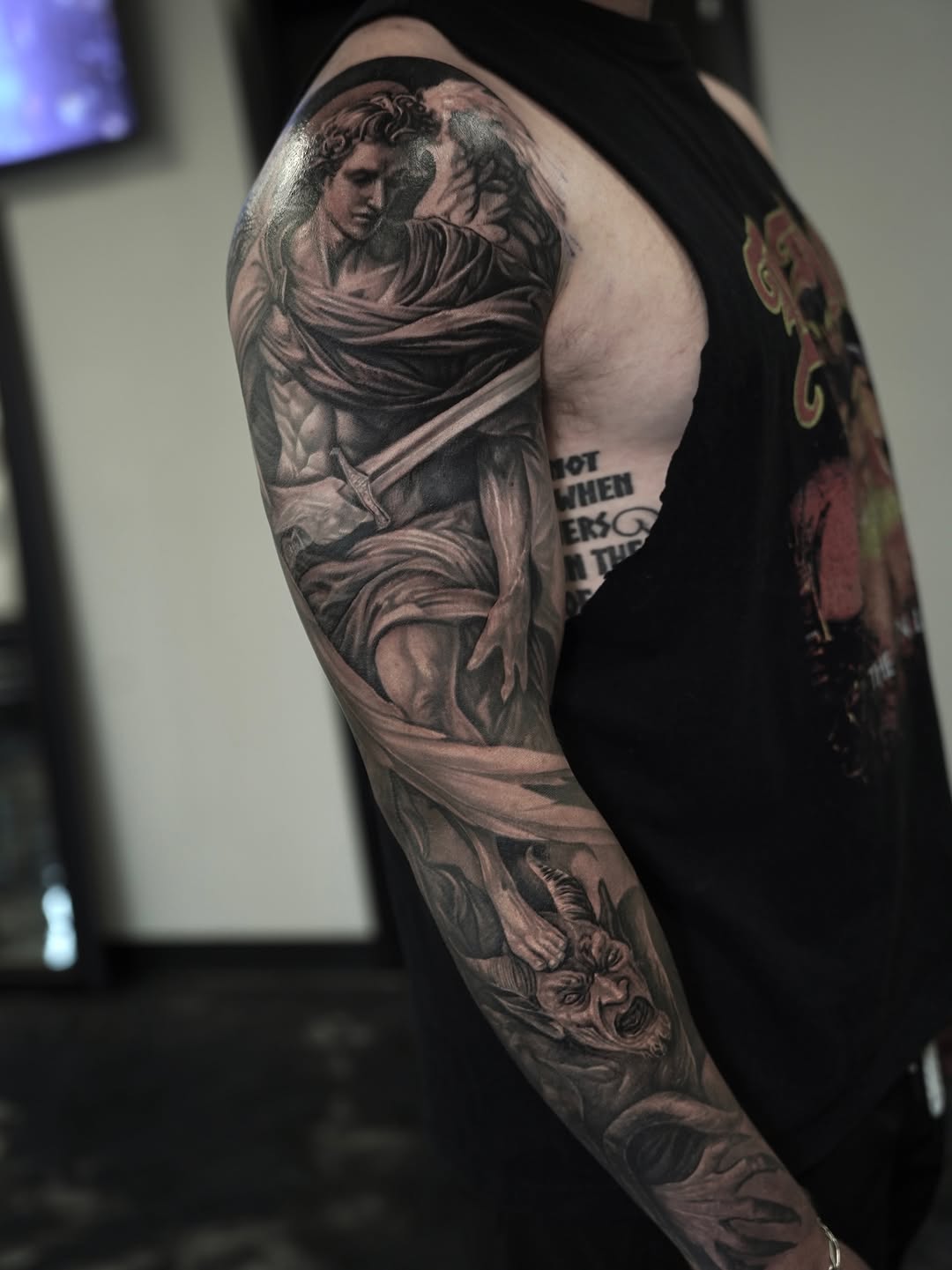 Angel and demon realism tattoo on the upper arm by Nelson Tellez