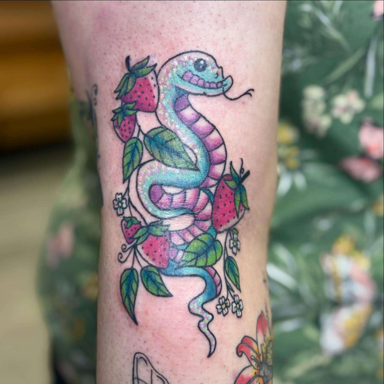 Snake and strawberries new school tattoo on the forearm by Taylor  Thompson