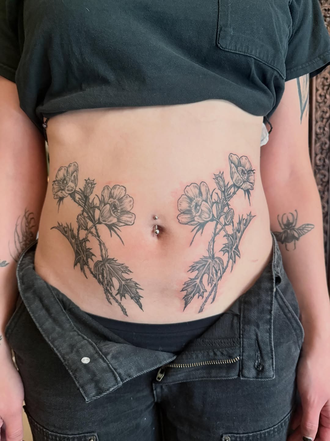 Poppies and leaves fine line tattoo on the torso by Emily Rose Lumsdaine
