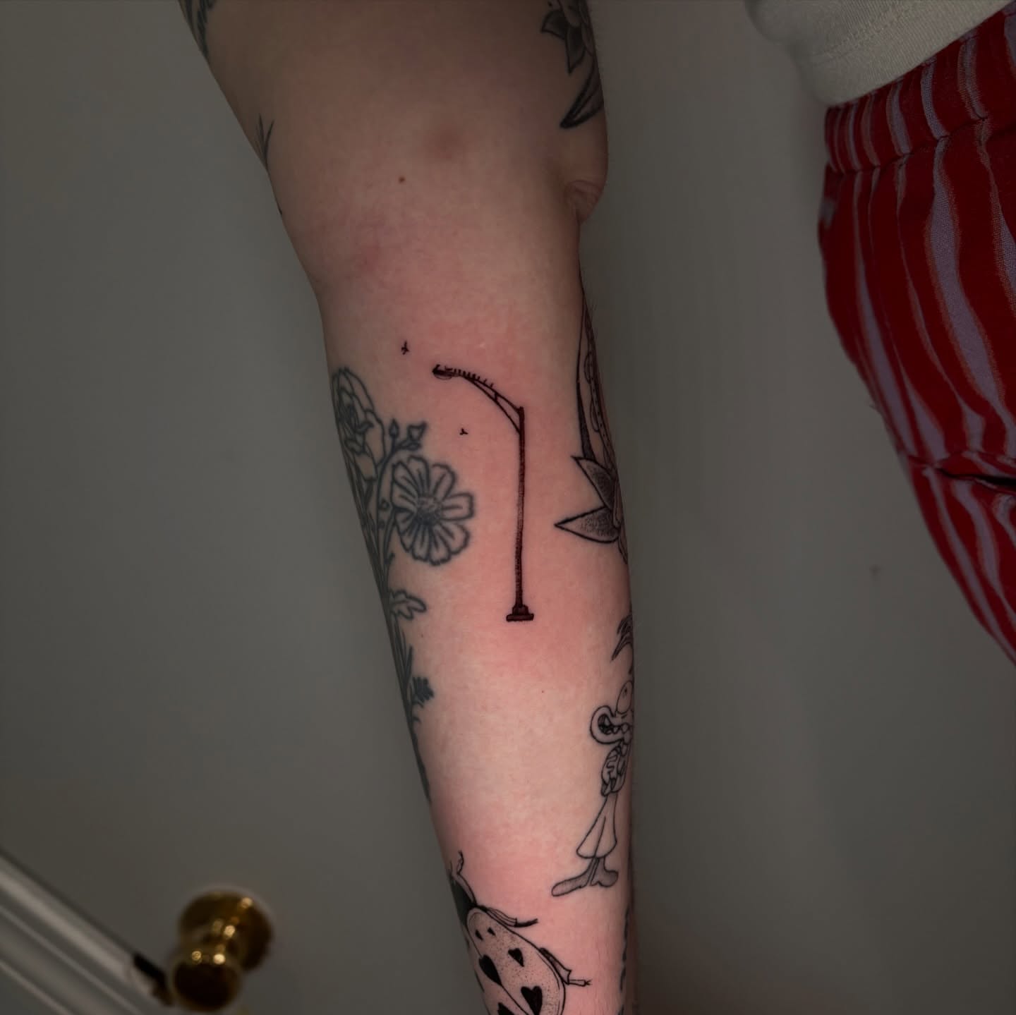 Fishing rod black and grey tattoo on the forearm by Chloe Shay