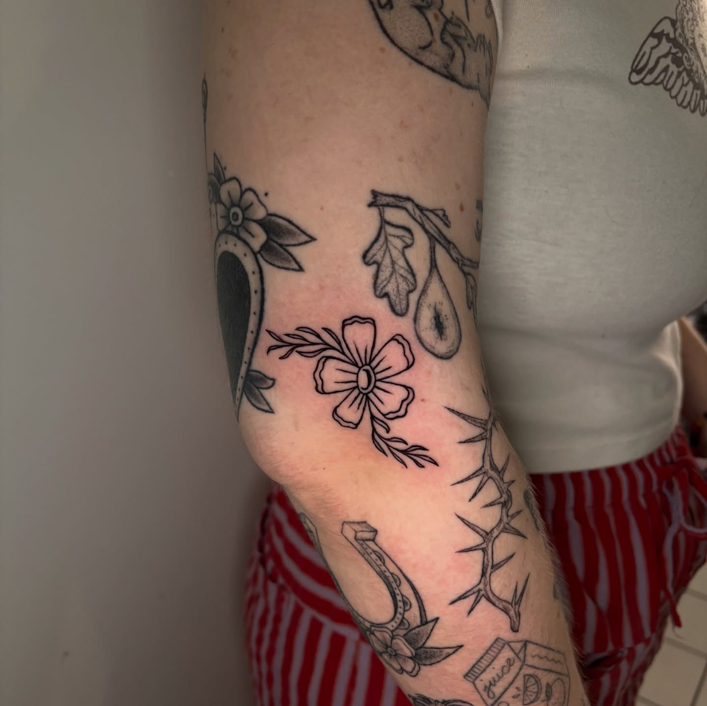 Flower and thorns black and grey tattoo on the forearm by Chloe Shay