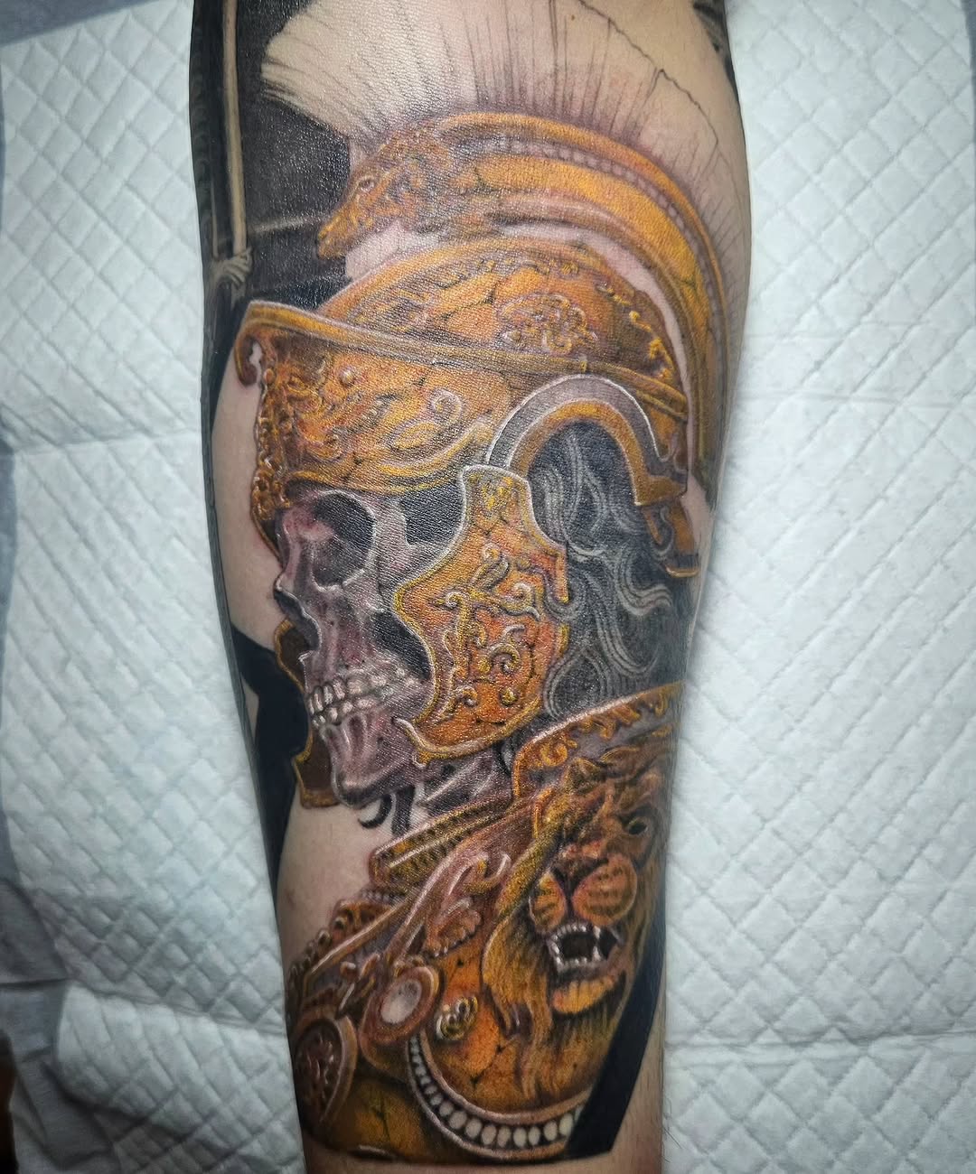 Skull in roman armor with lion realism tattoo on the forearm by Tattooer Hermin 허민