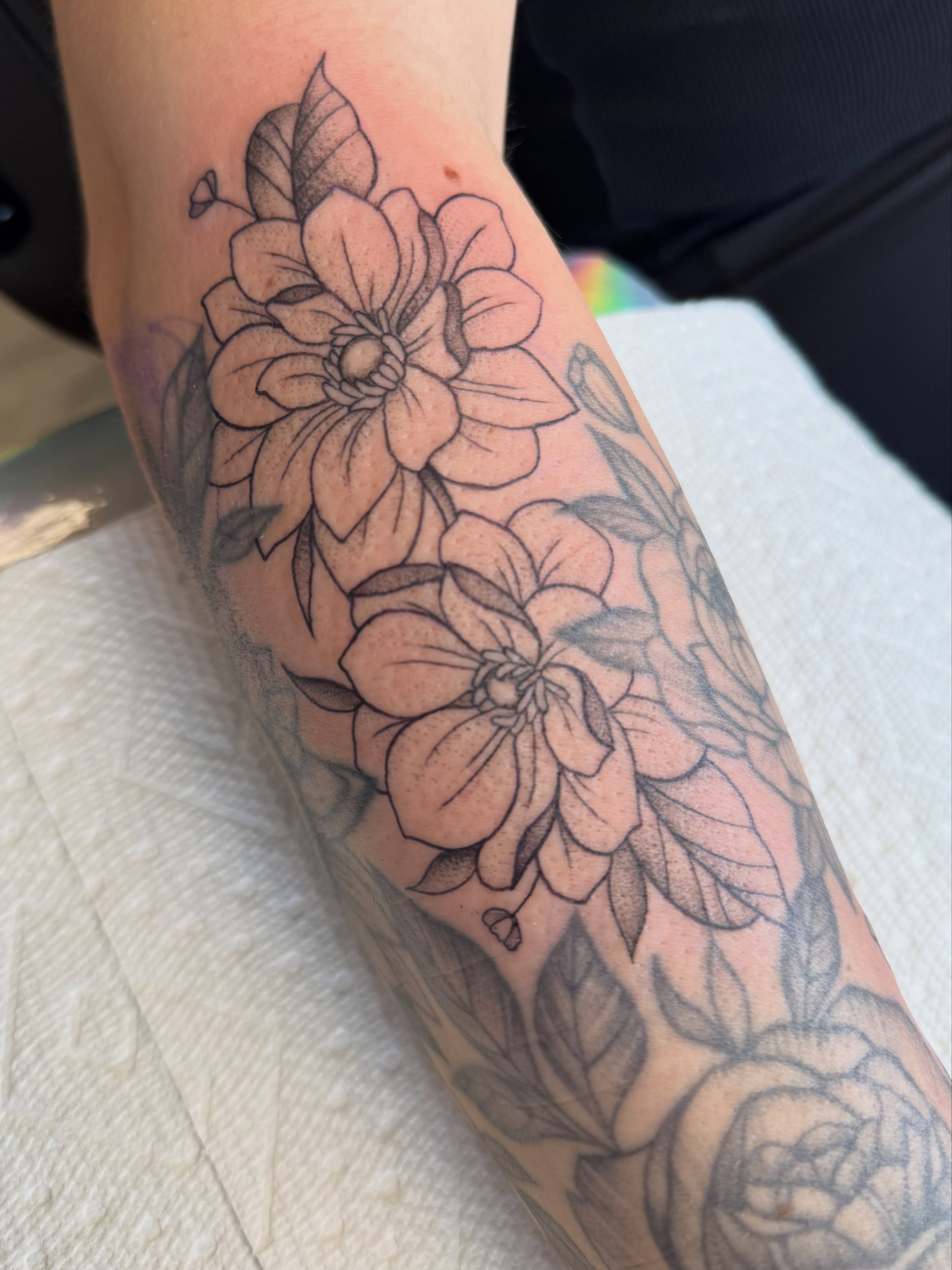 Flowers black and grey tattoo on the forearm by Alexx Colombo